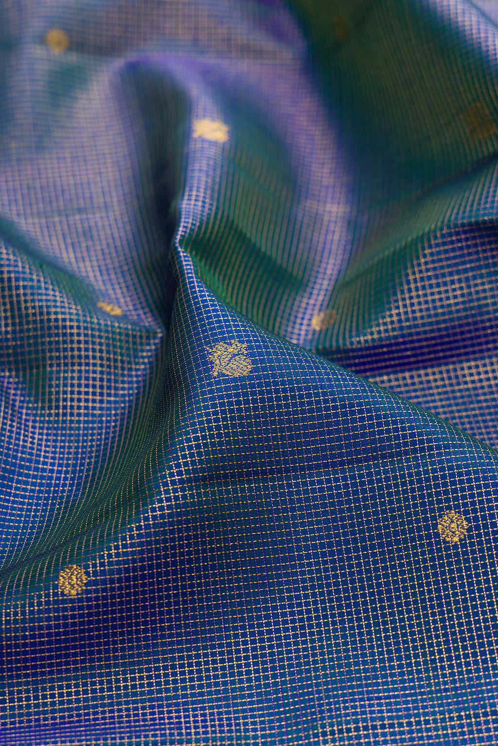 Close up of Peacock Blue Kanchipuram Silk Saree with Checked design on the body and Zari Border.  displaying folds