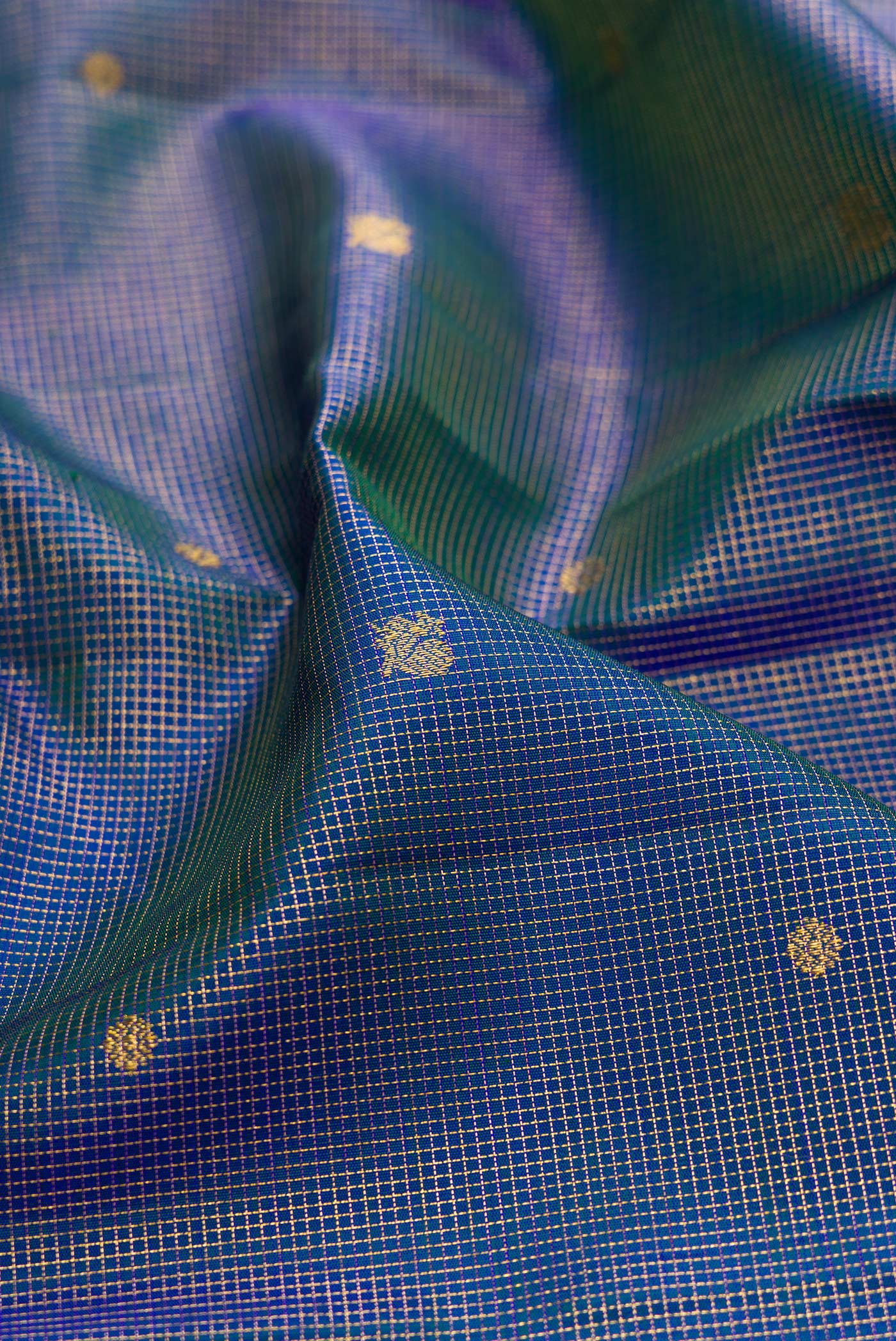 Close up of Peacock Blue Kanchipuram Silk Saree with Checked design on the body and Zari Border.  displaying folds