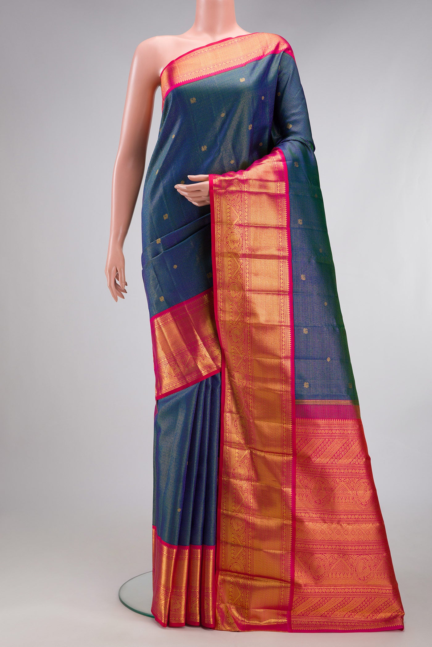 Peacock Blue Kanchipuram Silk Saree with Checked design on the body and Zari Border.  displayed on a mannequin