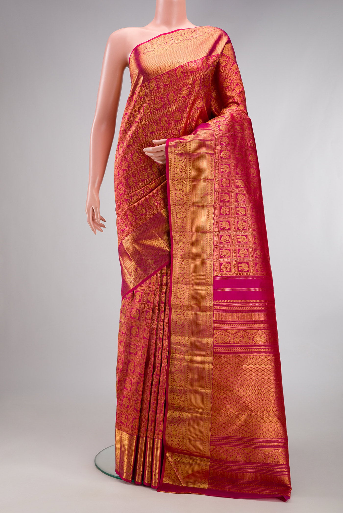 Rani Pink Kanchipuram Silk Saree with Zari Brocade on the body and Zari Border.  displayed on a mannequin