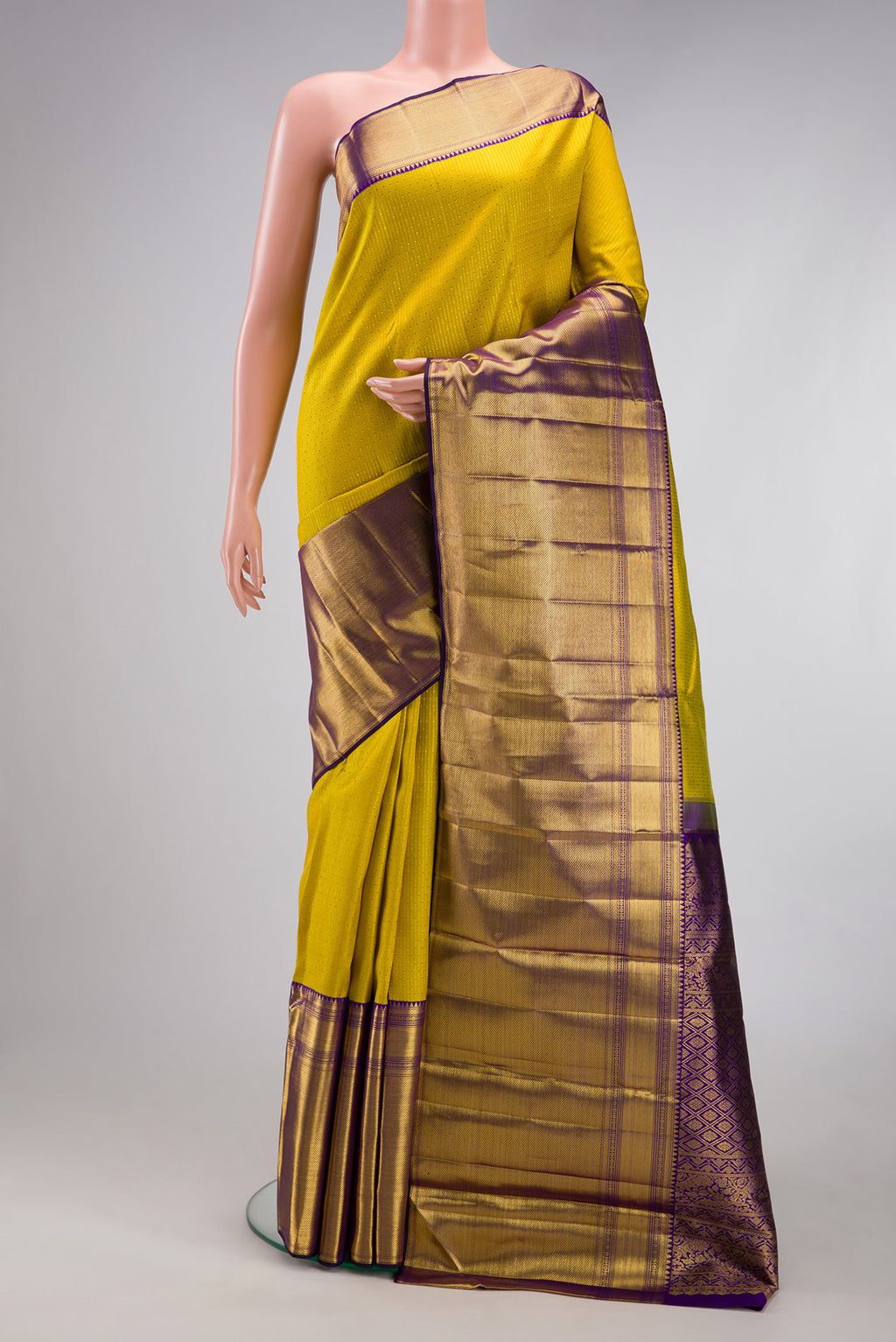 Yellow Kanchipuram Silk Saree with Zari Butta on the body and Fancy Border.  displayed on a mannequin