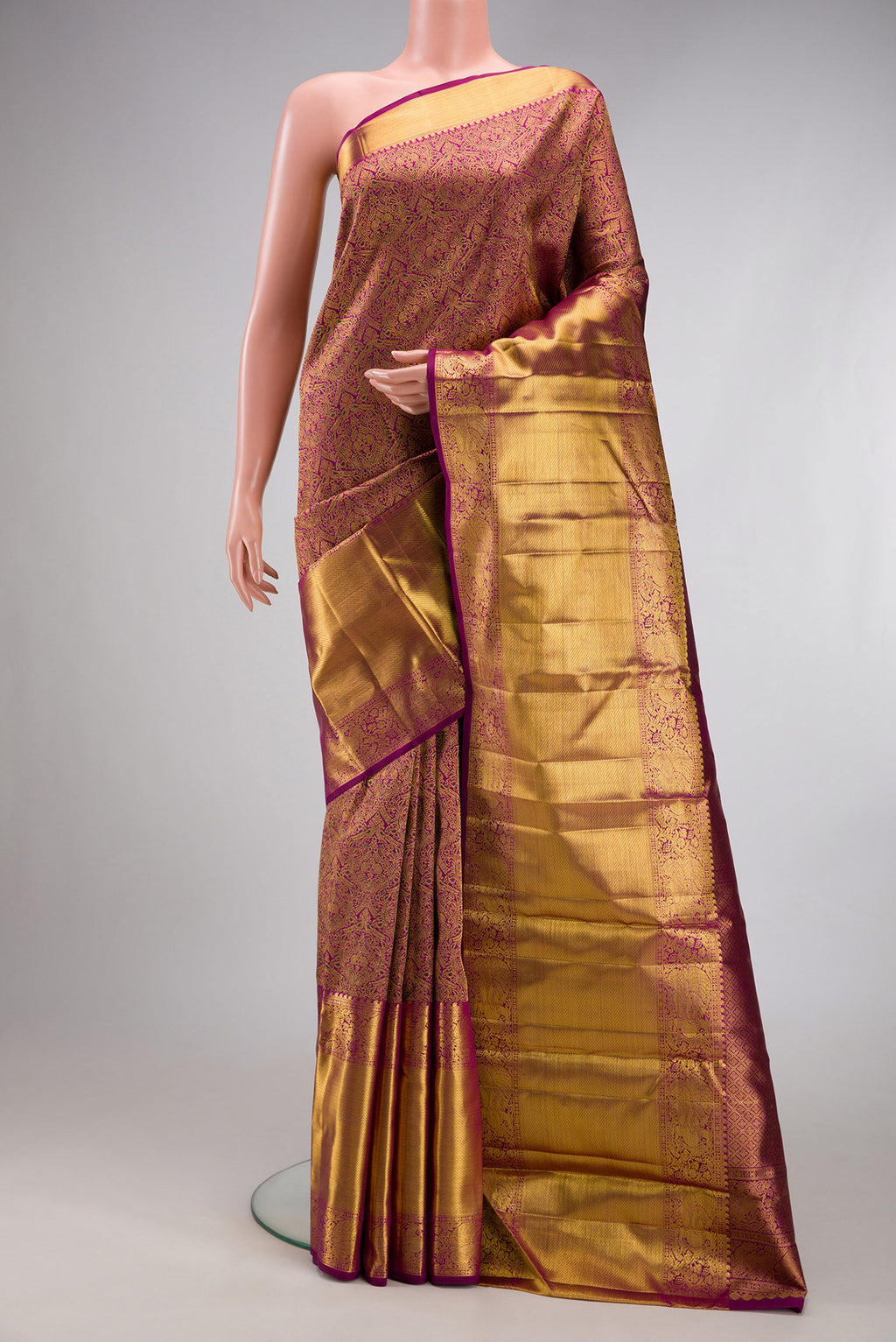 Magenta Kanchipuram Silk Saree with Zari Brocade on the body and Zari Border.  displayed on a mannequin