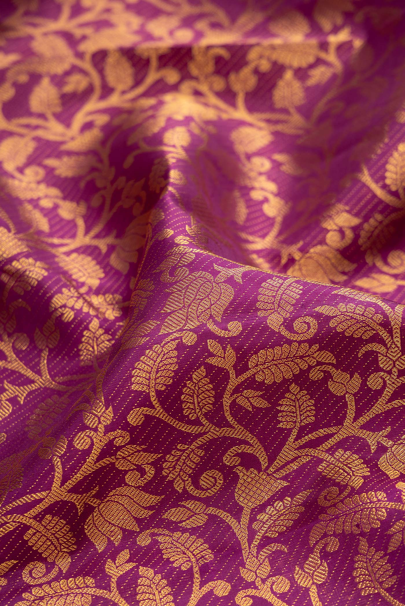 Close up of Purple Kanchipuram Silk Saree with Zari Brocade on the body and Zari Border.  displaying folds