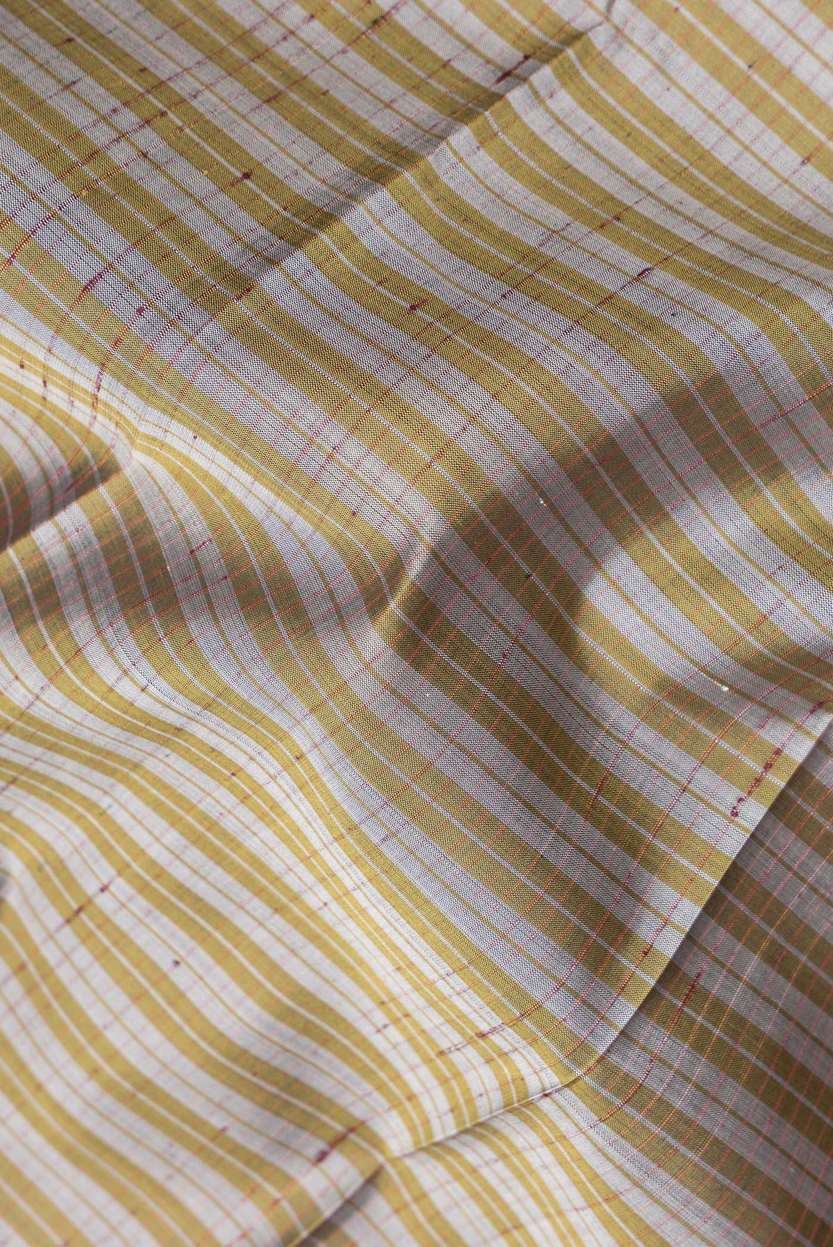 Close up of Pure Silk Grey Dual Tone Kanchipuram Saree with Checked design on the body and Zari Border.  displaying folds