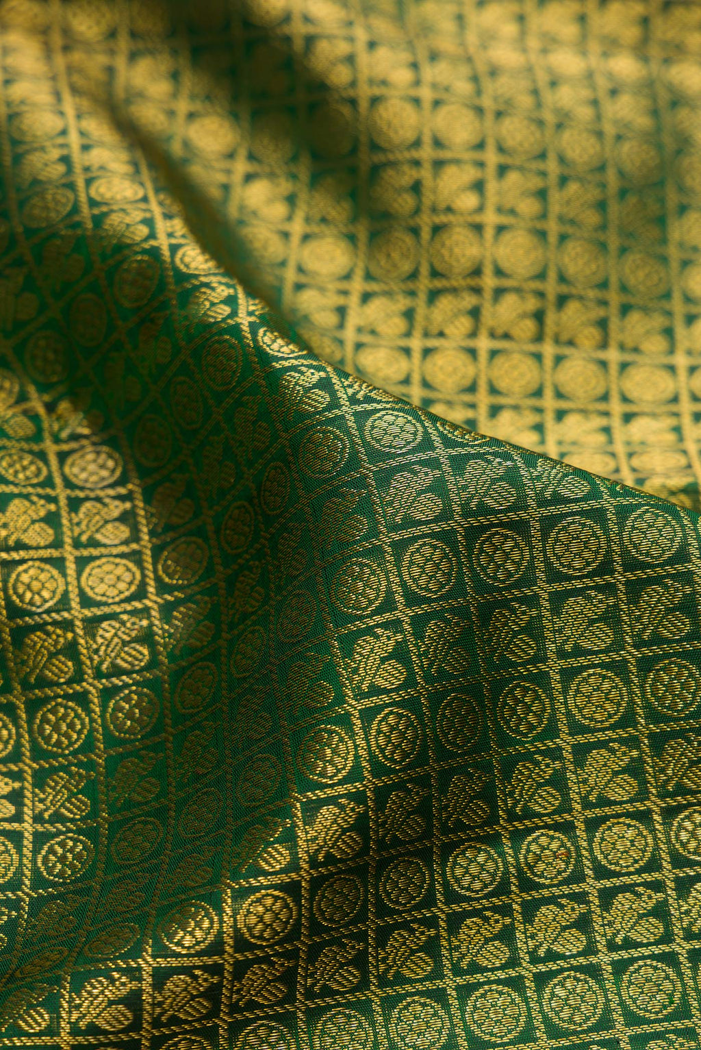 Close up of Bottle Green Kanchipuram Silk Saree with Zari Brocade on the body and Zari Border.  displaying folds