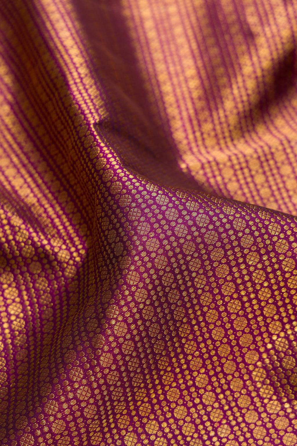 Close up of Magenta Kanchipuram Silk Saree with Zari Brocade on the body and Zari Border.  displaying folds