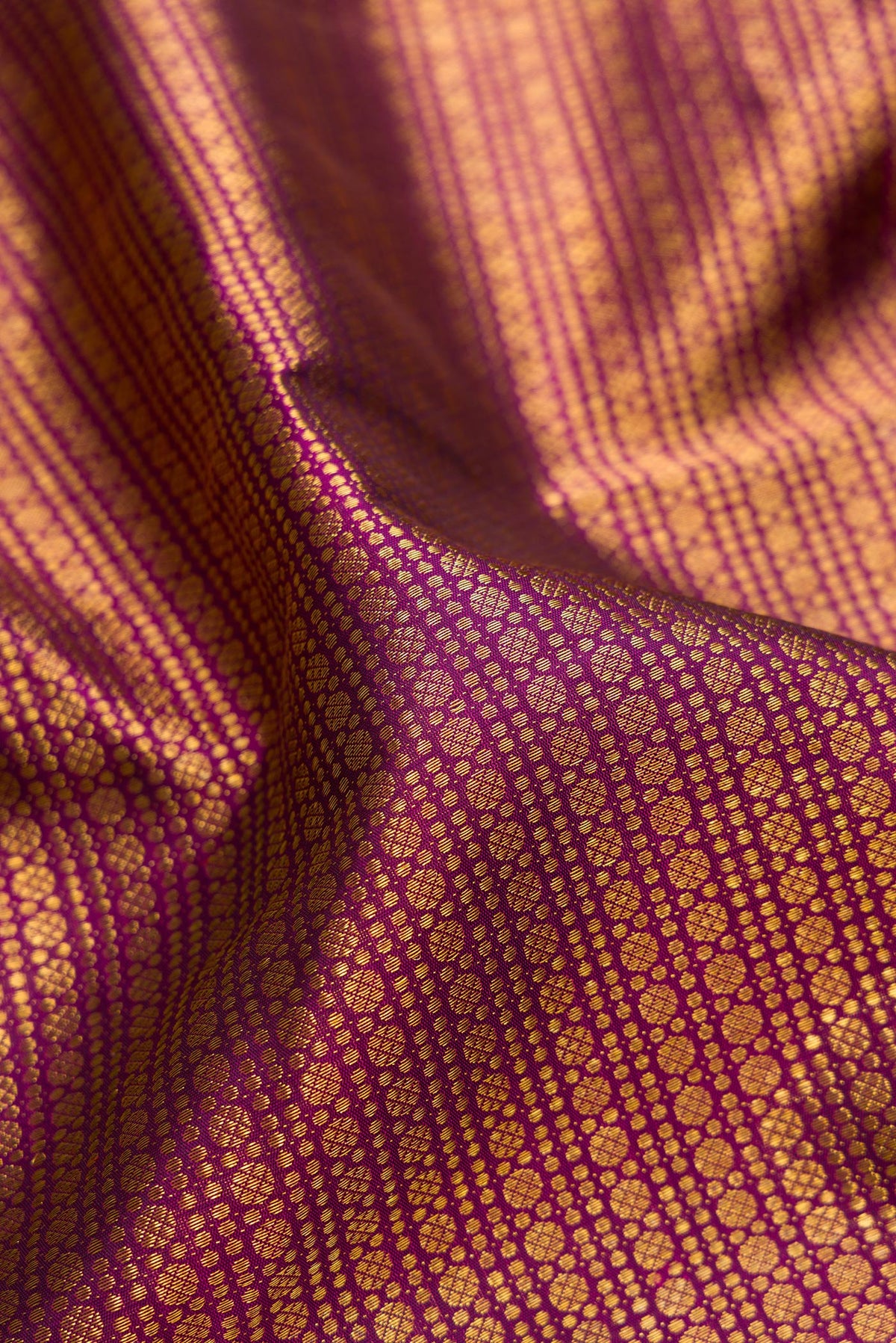 Close up of Magenta Kanchipuram Silk Saree with Zari Brocade on the body and Zari Border.  displaying folds