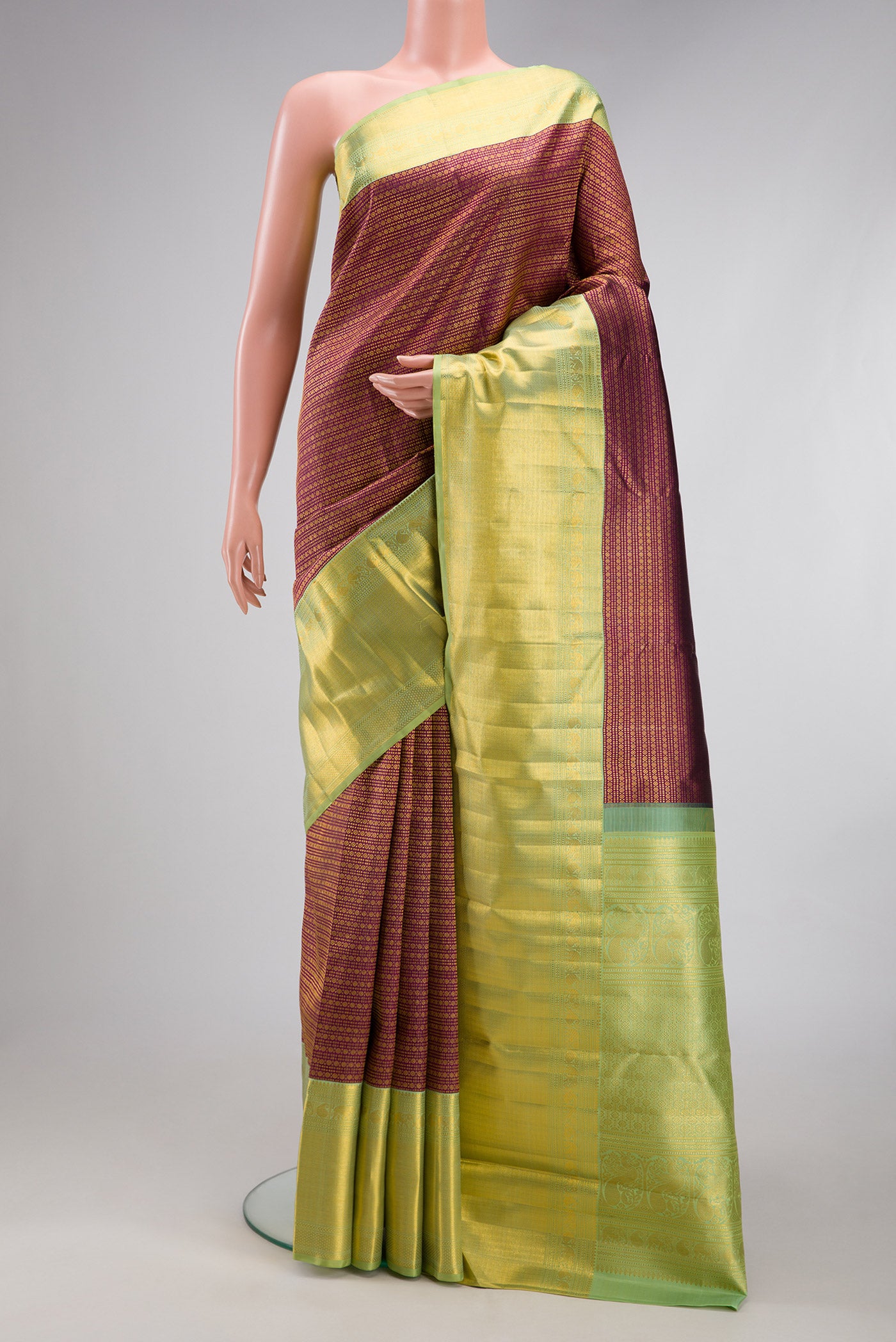 Magenta Kanchipuram Silk Saree with Zari Brocade on the body and Zari Border.  displayed on a mannequin