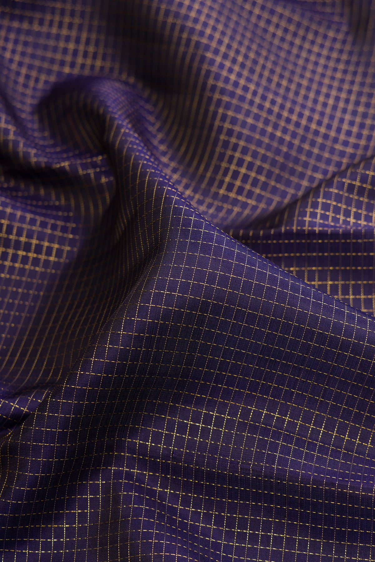 Close up of Pure Silk Navy Blue Kanchipuram Saree with Checked design on the body and Zari Border.  displaying folds