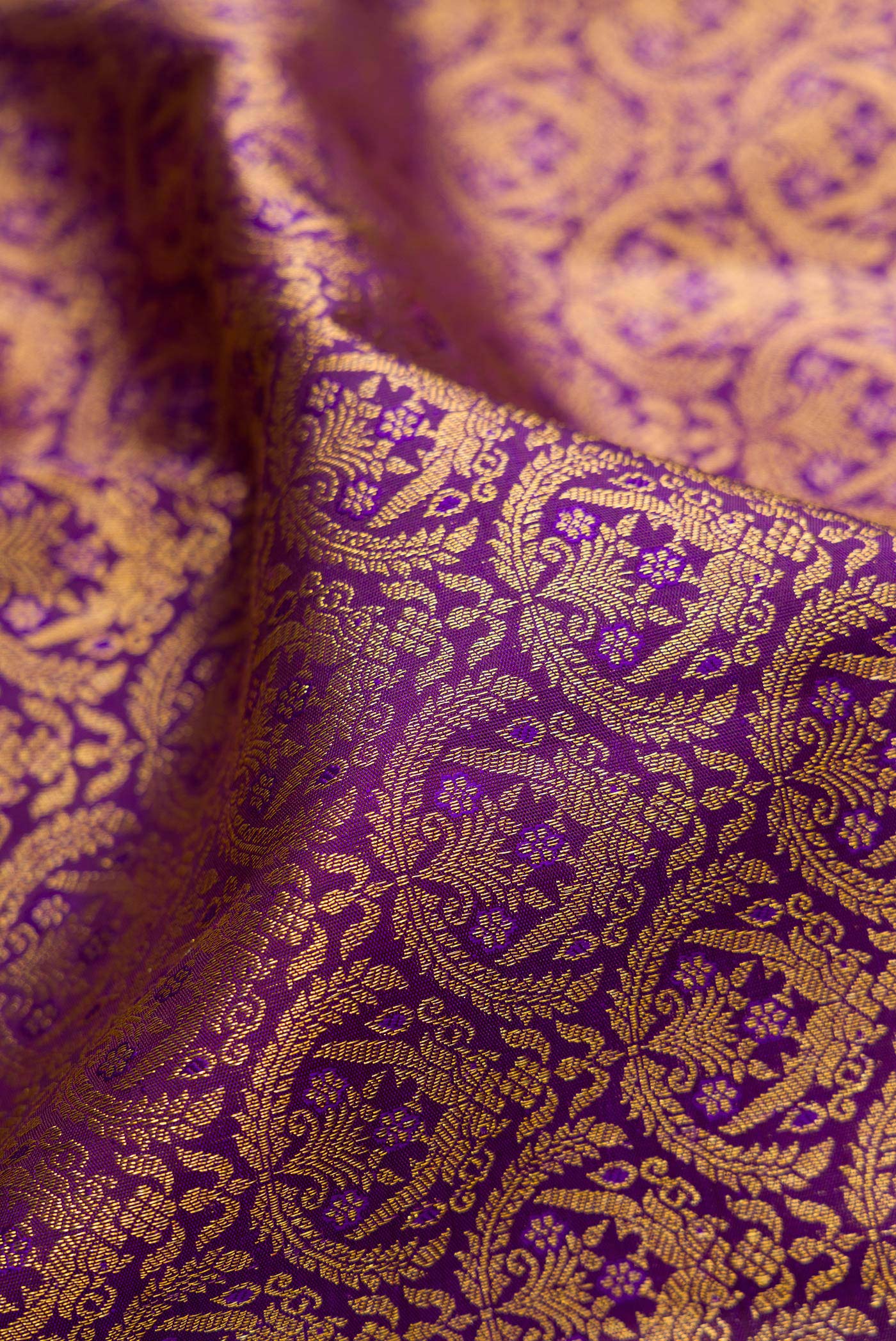 Close up of Purple Kanchipuram Silk Saree with Zari Brocade on the body and Zari Border.  displaying folds