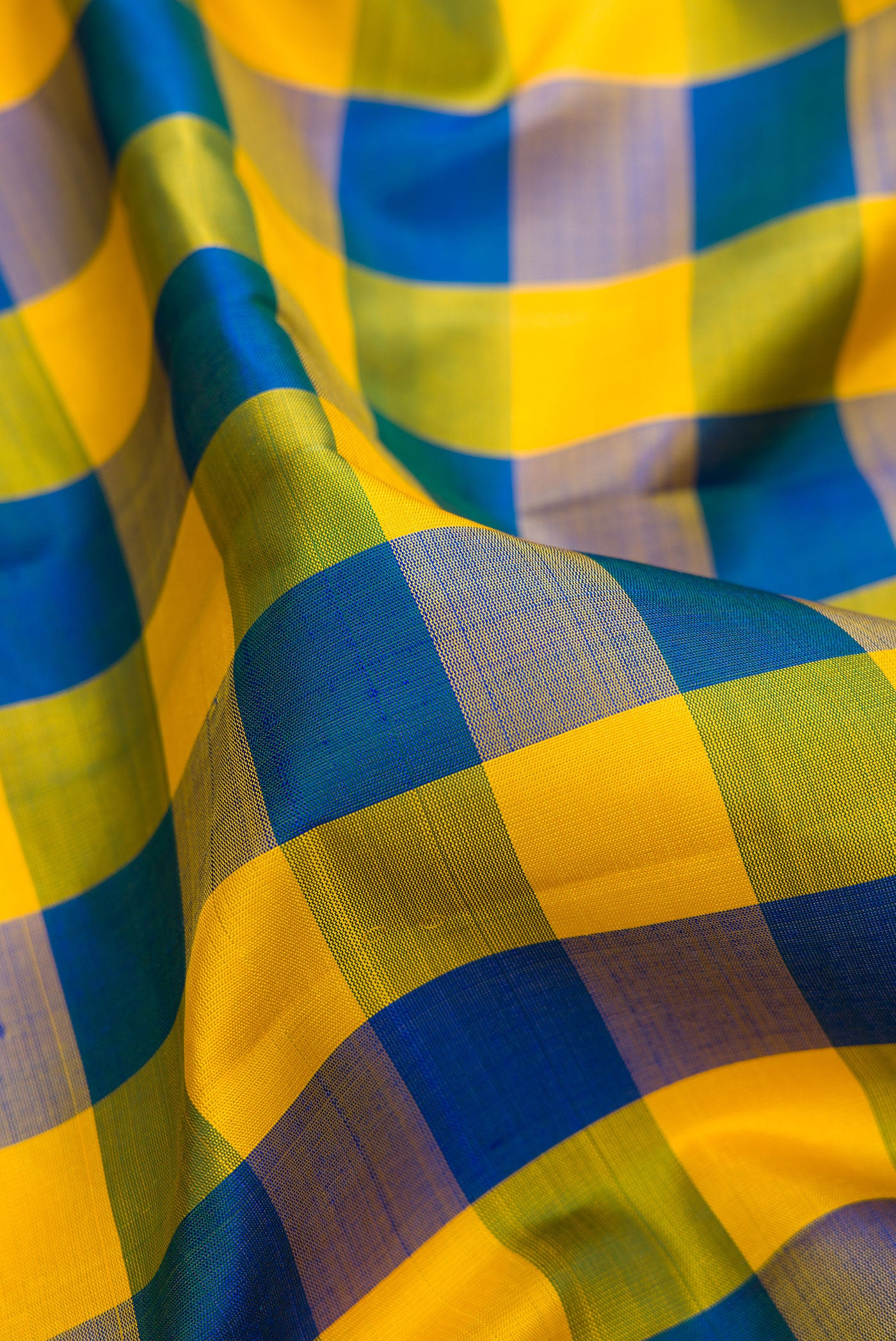 Close up of Multi Color Kanjivaram Silk Saree with Checked design on the body and Zari Border.  displaying folds