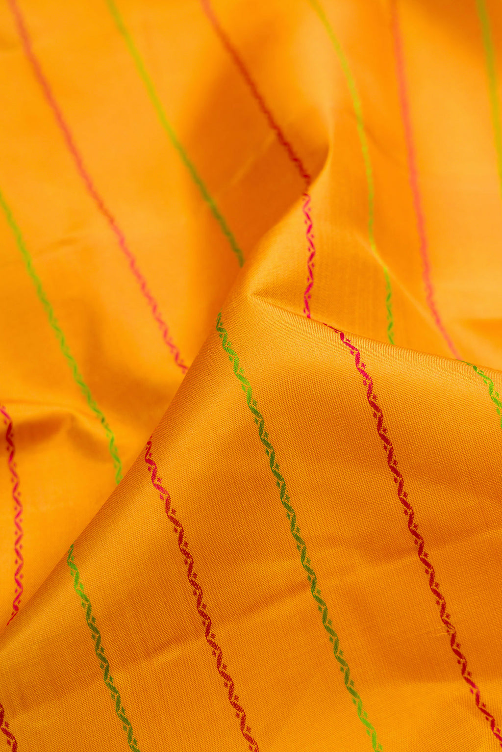 Close up of Mustard Kanjivaram Silk Saree with Veldhari on the body and Thread Border.  displaying folds