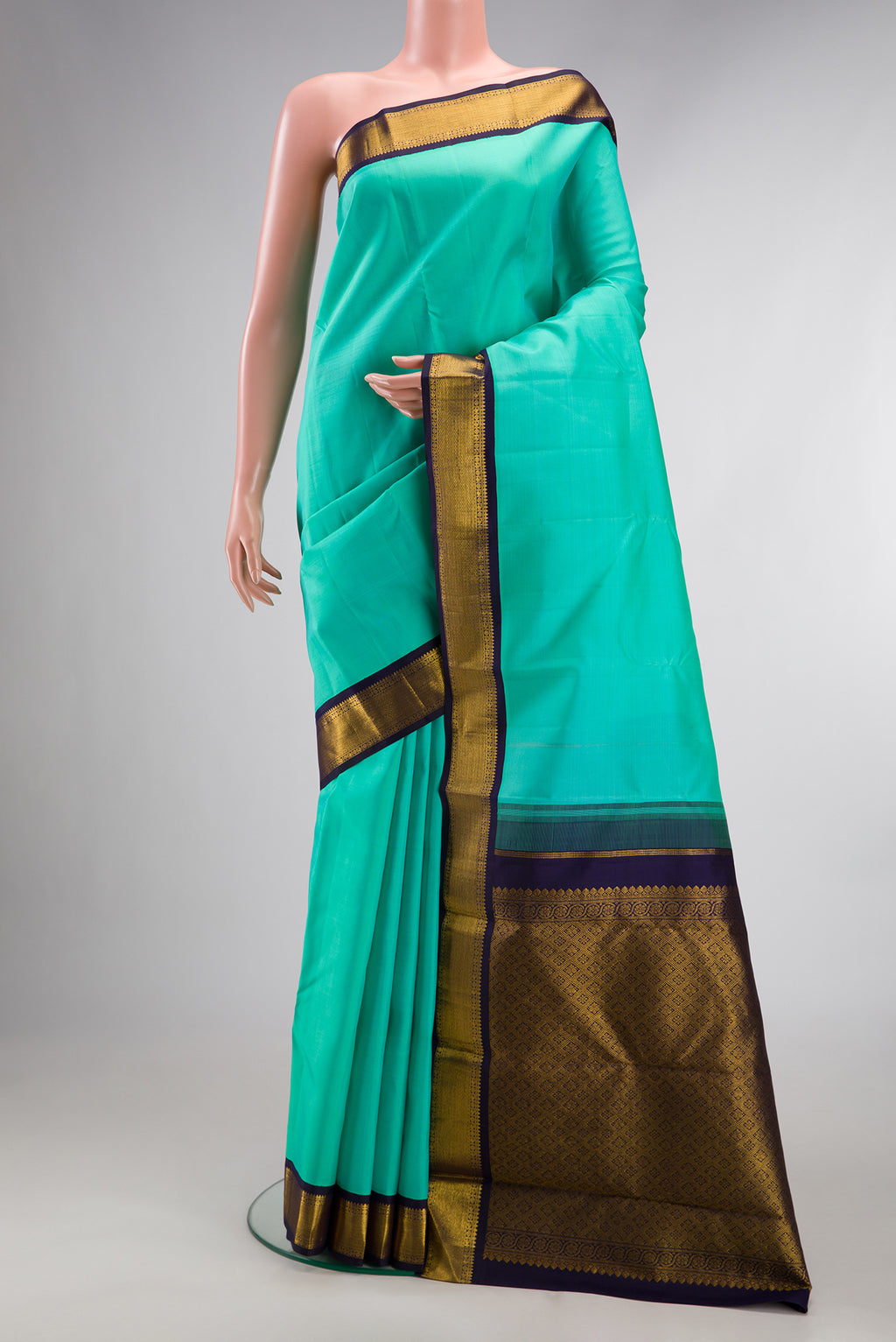 Pure Silk Sea Green Kanjivaram Saree with Plain Body and Zari Border.  displayed on a mannequin