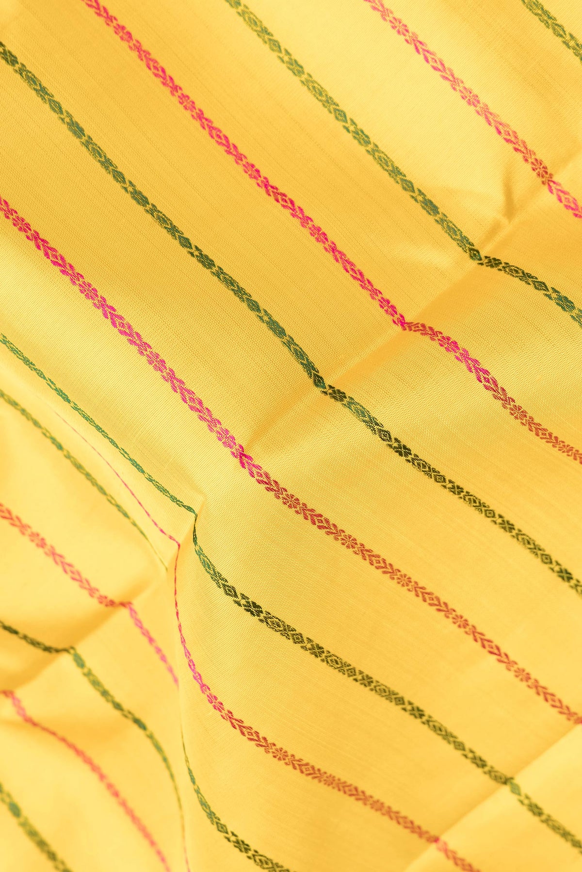 Close up of Pure Silk Yellow Kanchipuram Saree with Veldhari on the body and Thread Border.  displaying folds