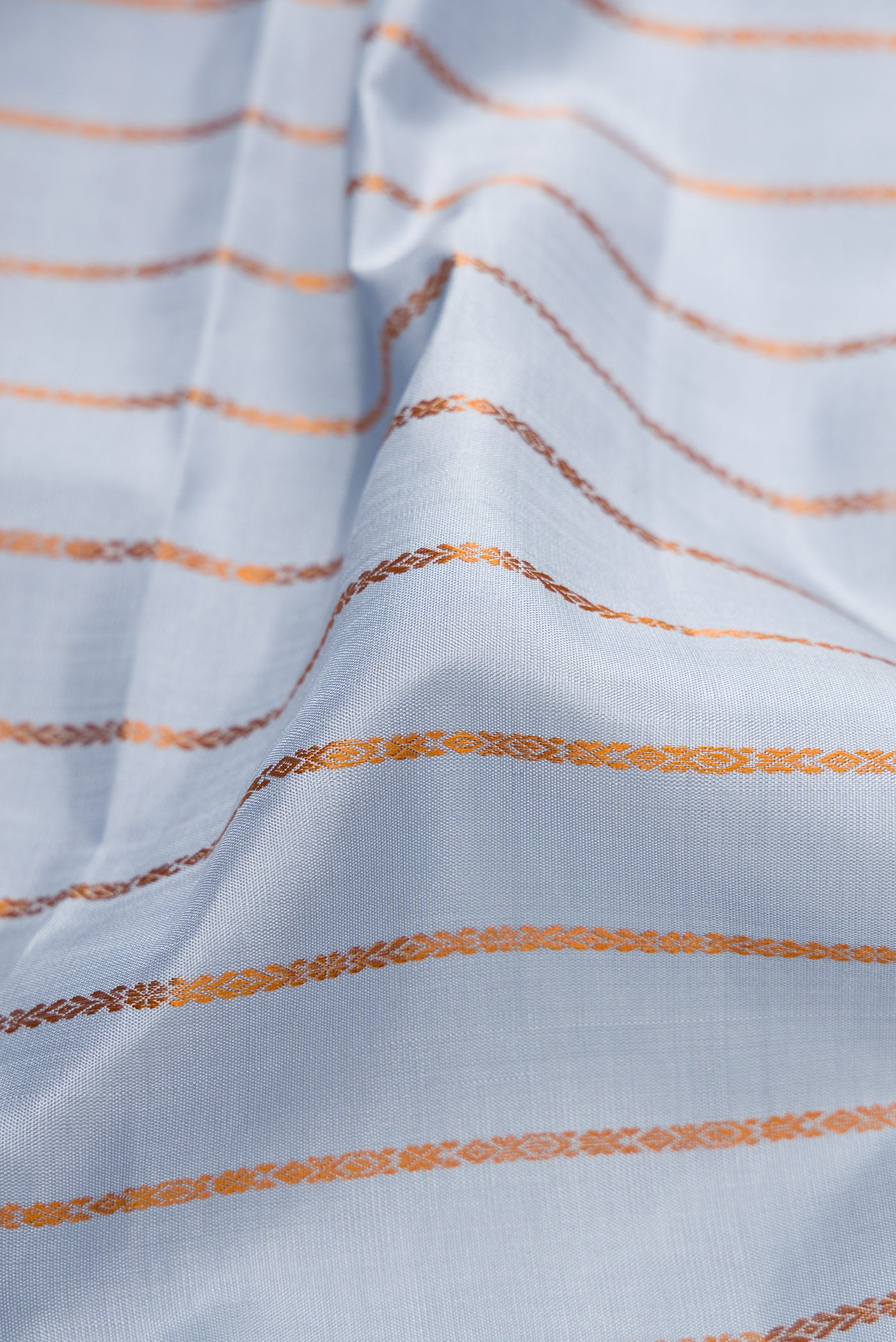 Close up of Lilac Kanjivaram Silk Saree with Veldhari on the body and Thread Border.  displaying folds