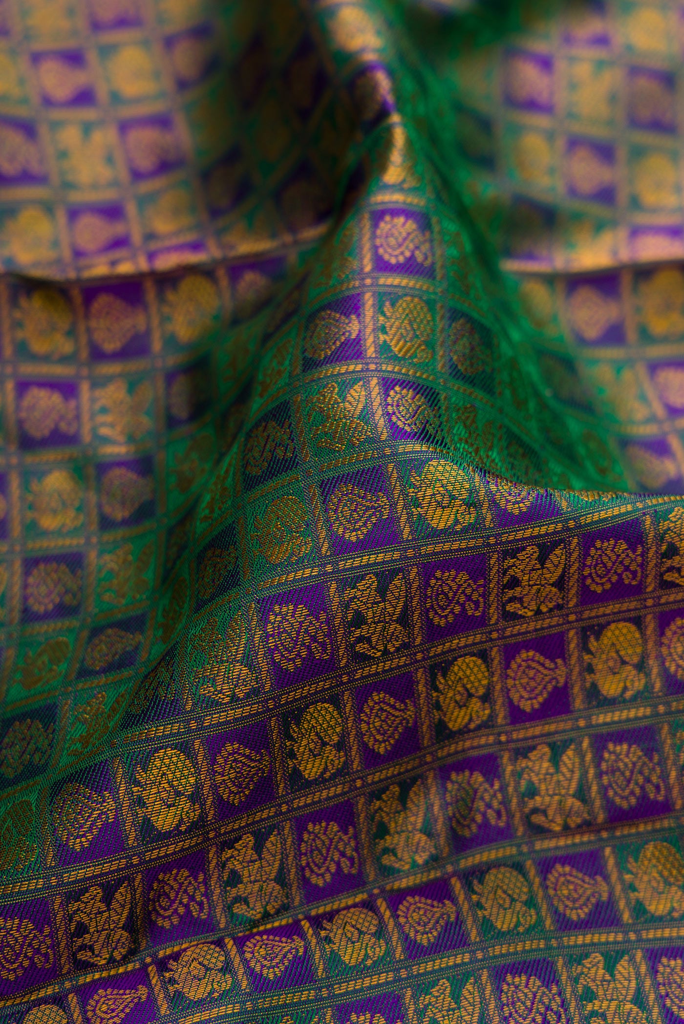 Close up of Peacock Blue Dual Tone Kanjivaram Silk Saree with Jacquard design on the body and Thread Border.  displaying folds