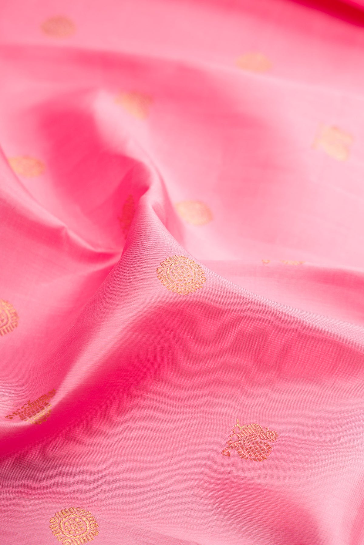 Close up of Pure Silk Pure Zari Rose pink Kanjivaram Saree with Zari Butta on the body and Zari Border.  displaying folds