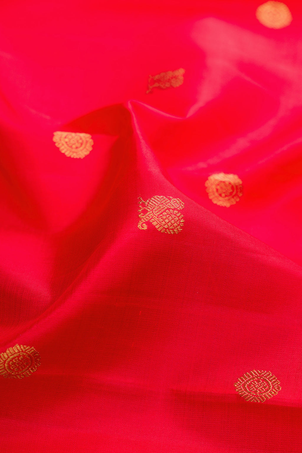 Close up of Pure Silk Pure Zari Red Kanjivaram Saree with Zari Butta on the body and Zari Border.  displaying folds