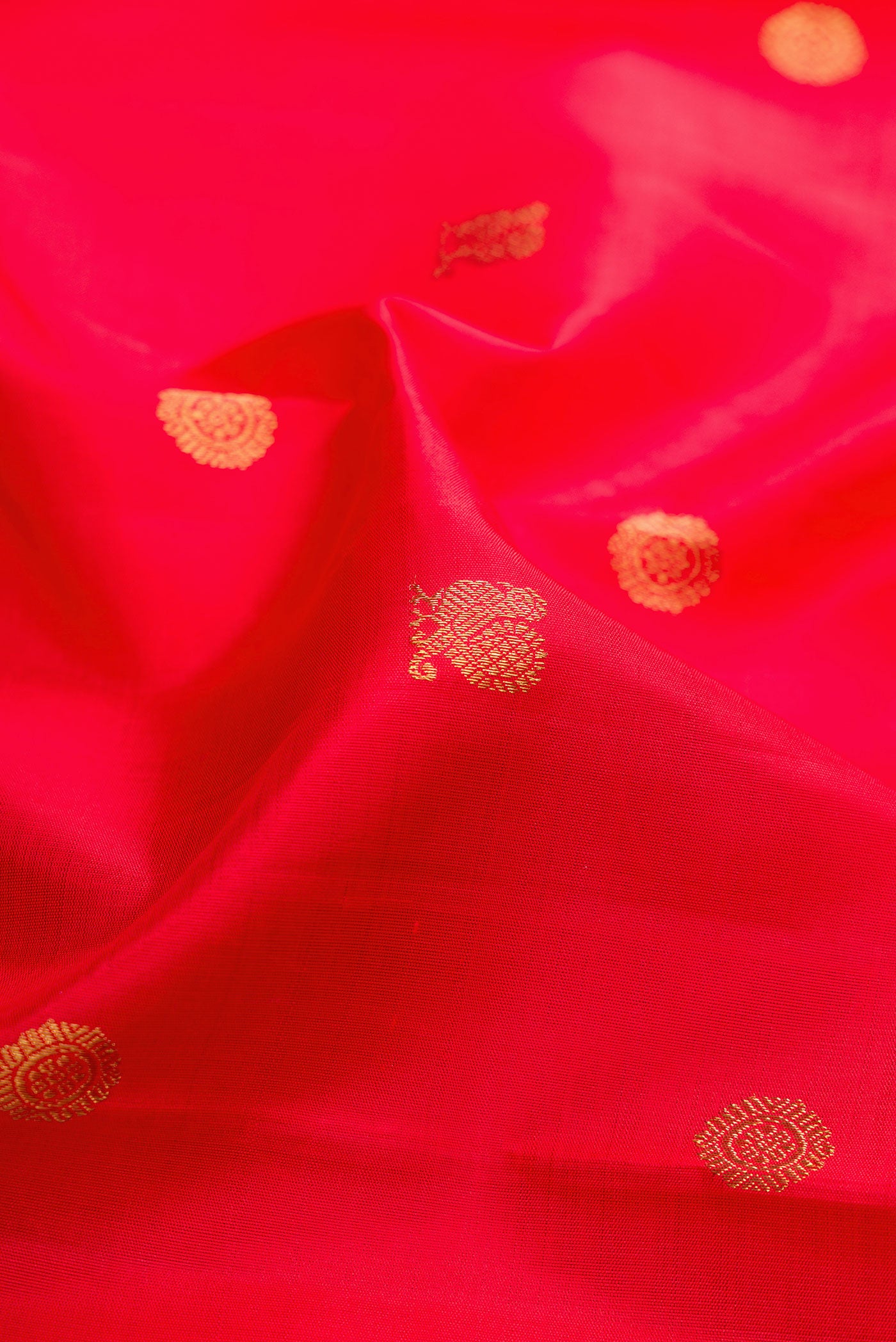 Close up of Pure Silk Pure Zari Red Kanjivaram Saree with Zari Butta on the body and Zari Border.  displaying folds
