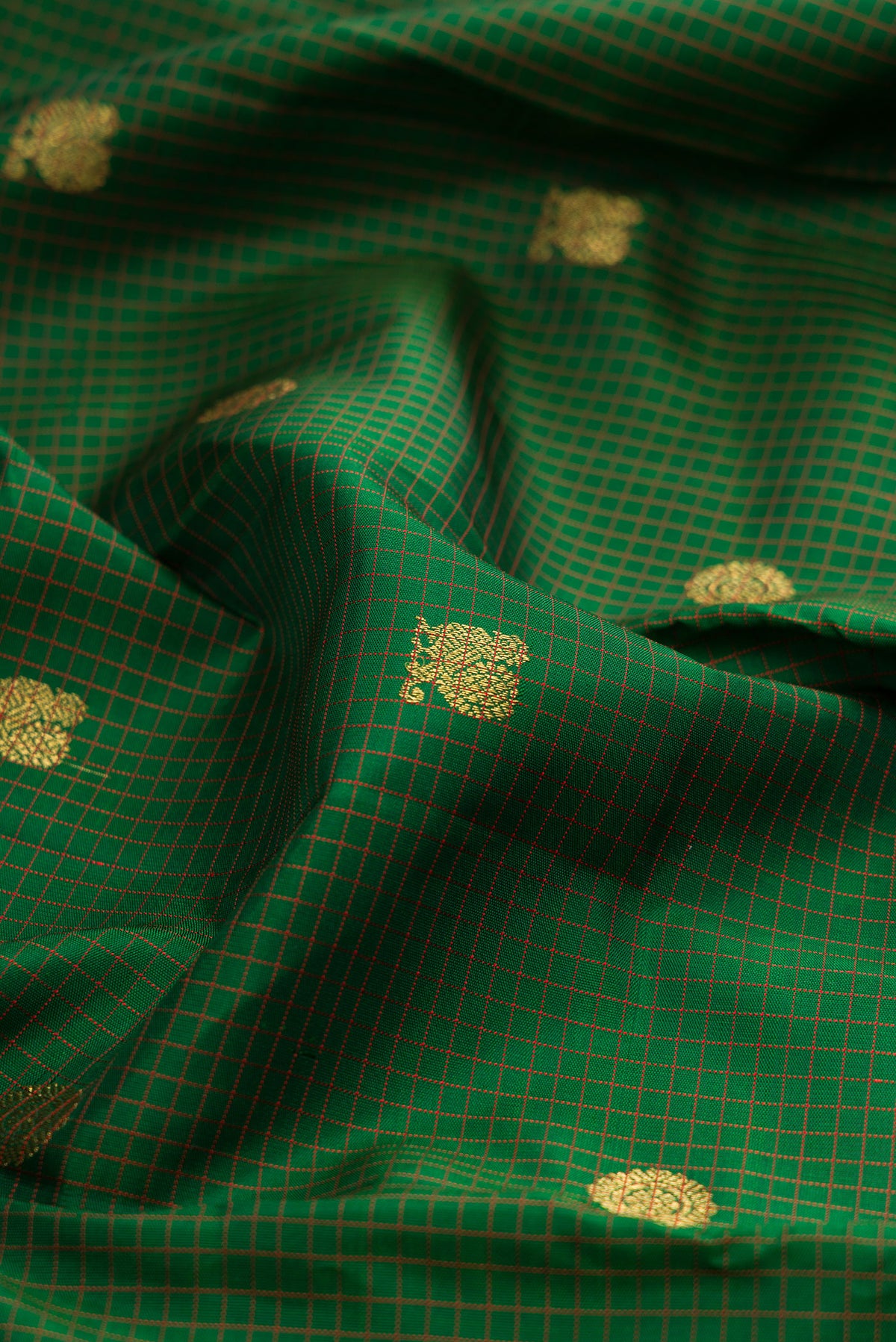 Close up of Pure Silk Pure Zari Green Kanjivaram Saree with Zari Butta on the body and Zari Border.  displaying folds