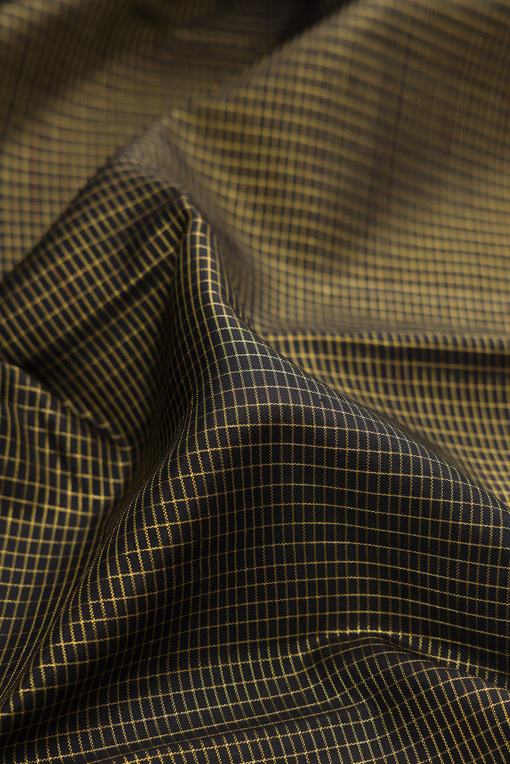 Close up of Black Kanchipuram Silk Saree with Checked design on the body and Zari Border.  displaying folds