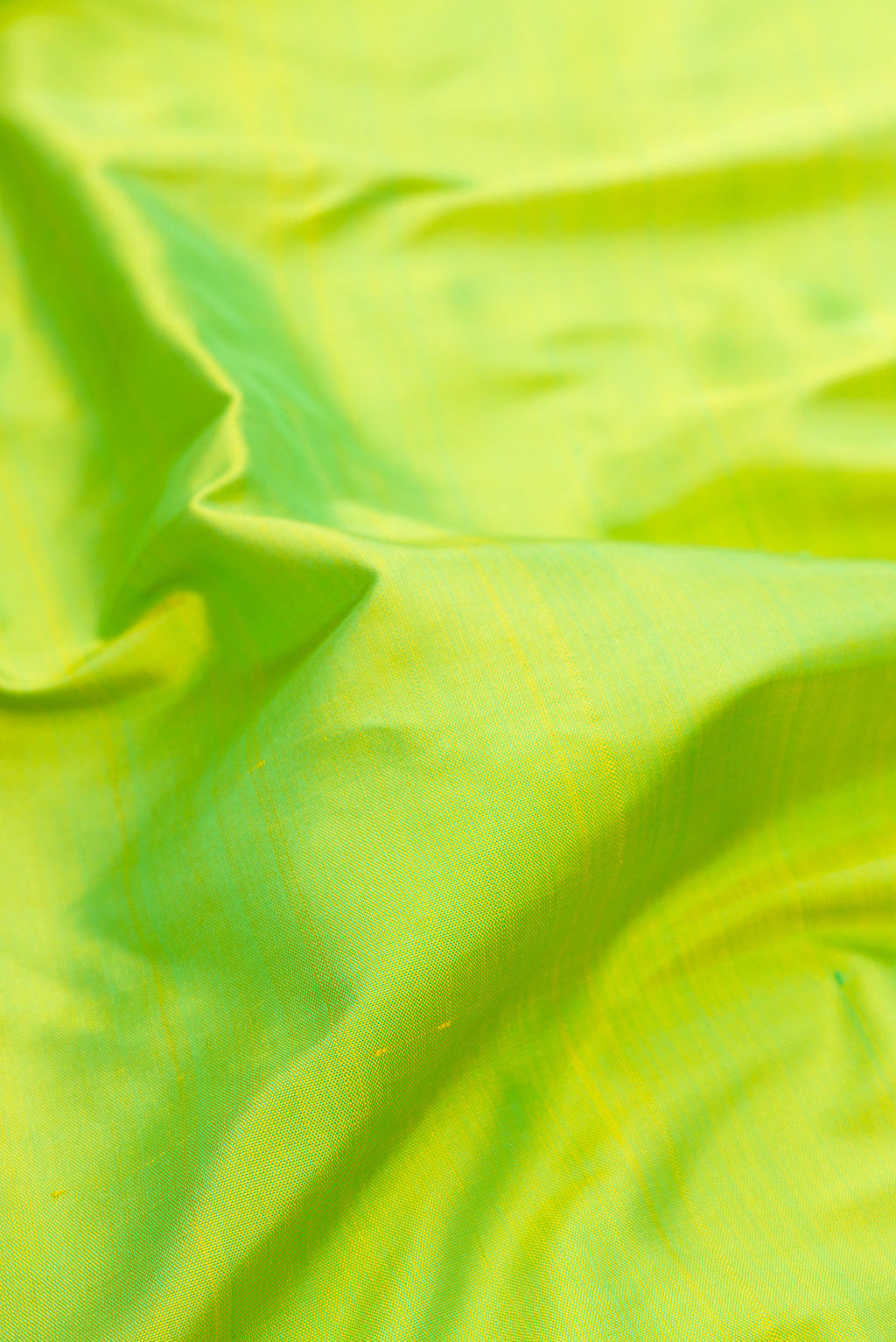 Close up of Pure Silk Pure Zari Parrot Green Kanjivaram Saree with Plain Body and One Side Border.  displaying folds