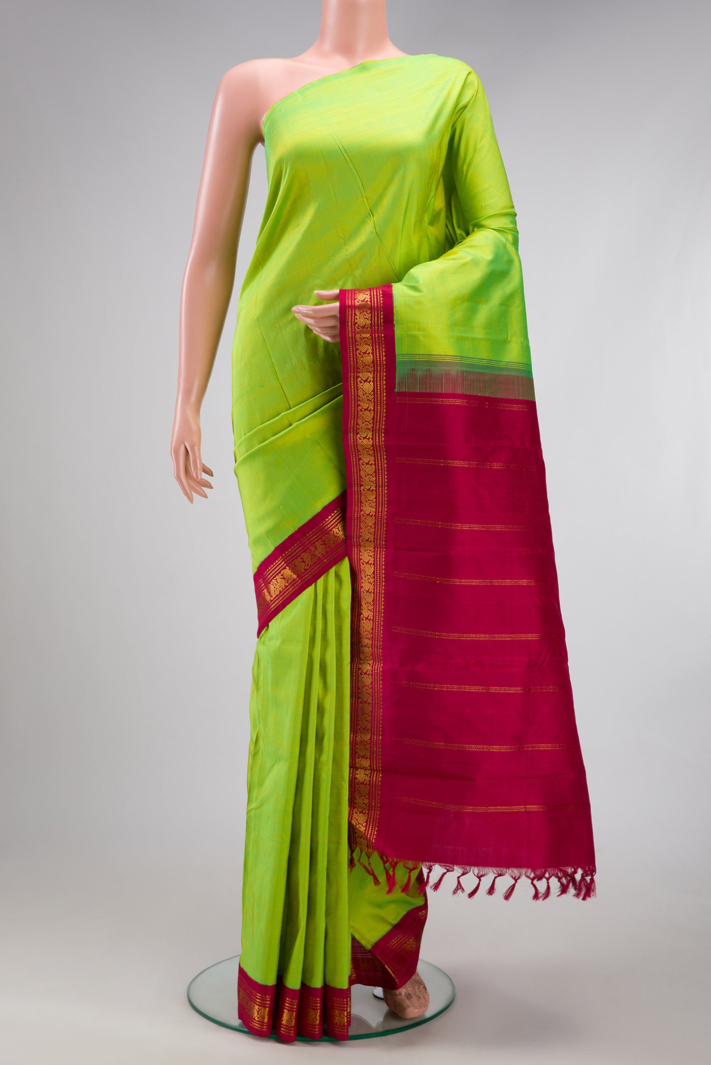 Pure Silk Pure Zari Parrot Green Kanjivaram Saree with Plain Body and One Side Border.  displayed on a mannequin