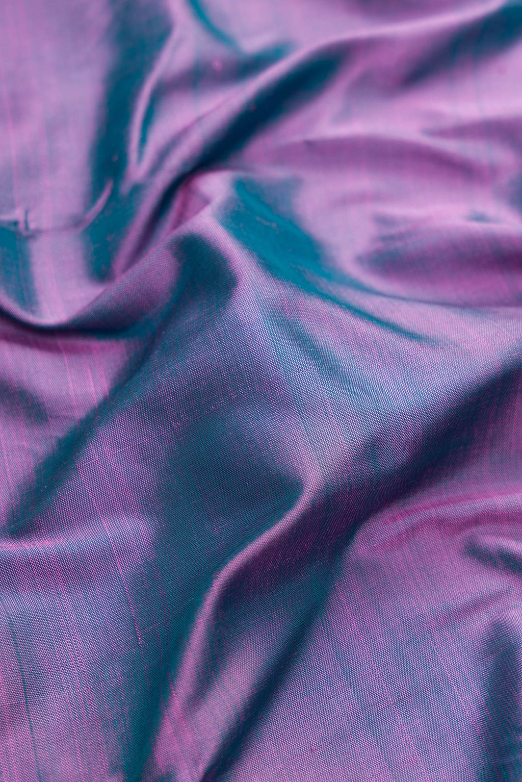 Close up of Pure Silk Pure Zari Purple Dual Tone Kanjivaram Saree with Plain Body and One Side Border.  displaying folds