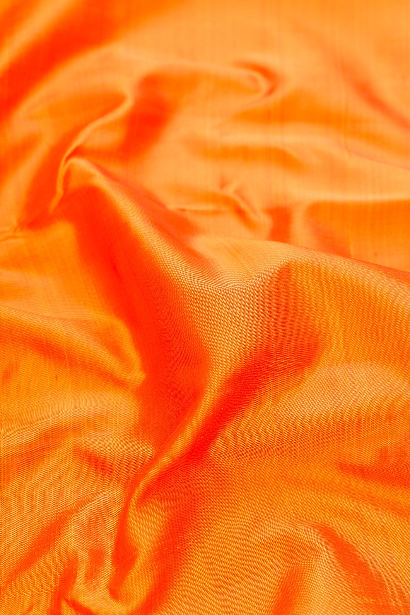 Close up of Pure Silk Pure Zari Orange Kanjivaram Saree with Plain Body and One Side Border.  displaying folds