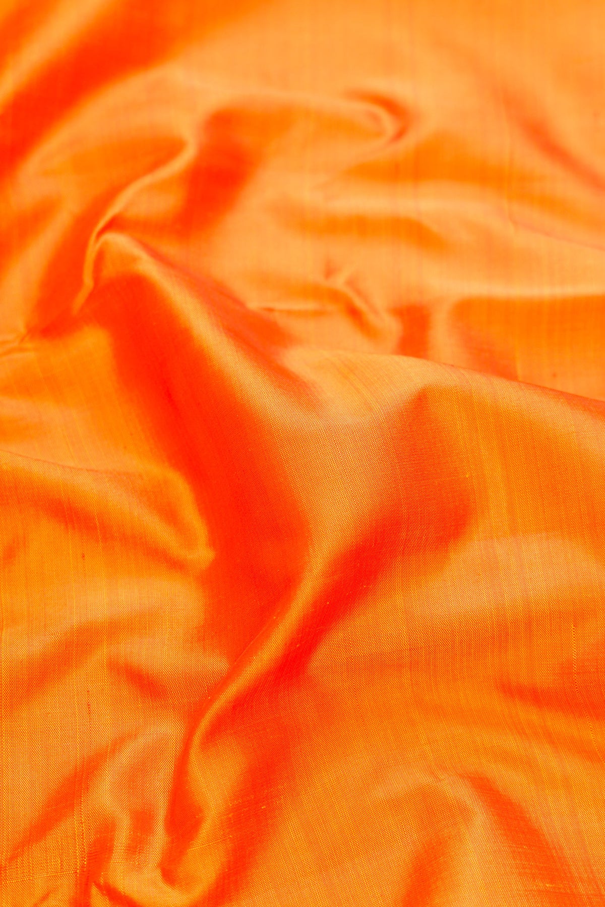Close up of Pure Silk Pure Zari Orange Kanjivaram Saree with Plain Body and One Side Border.  displaying folds