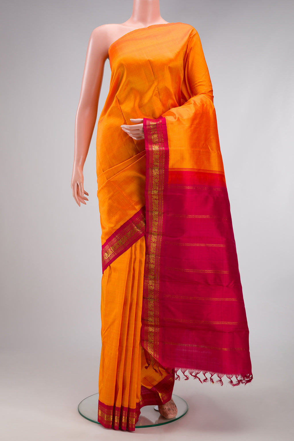 Pure Silk Pure Zari Orange Kanjivaram Saree with Plain Body and One Side Border.  displayed on a mannequin