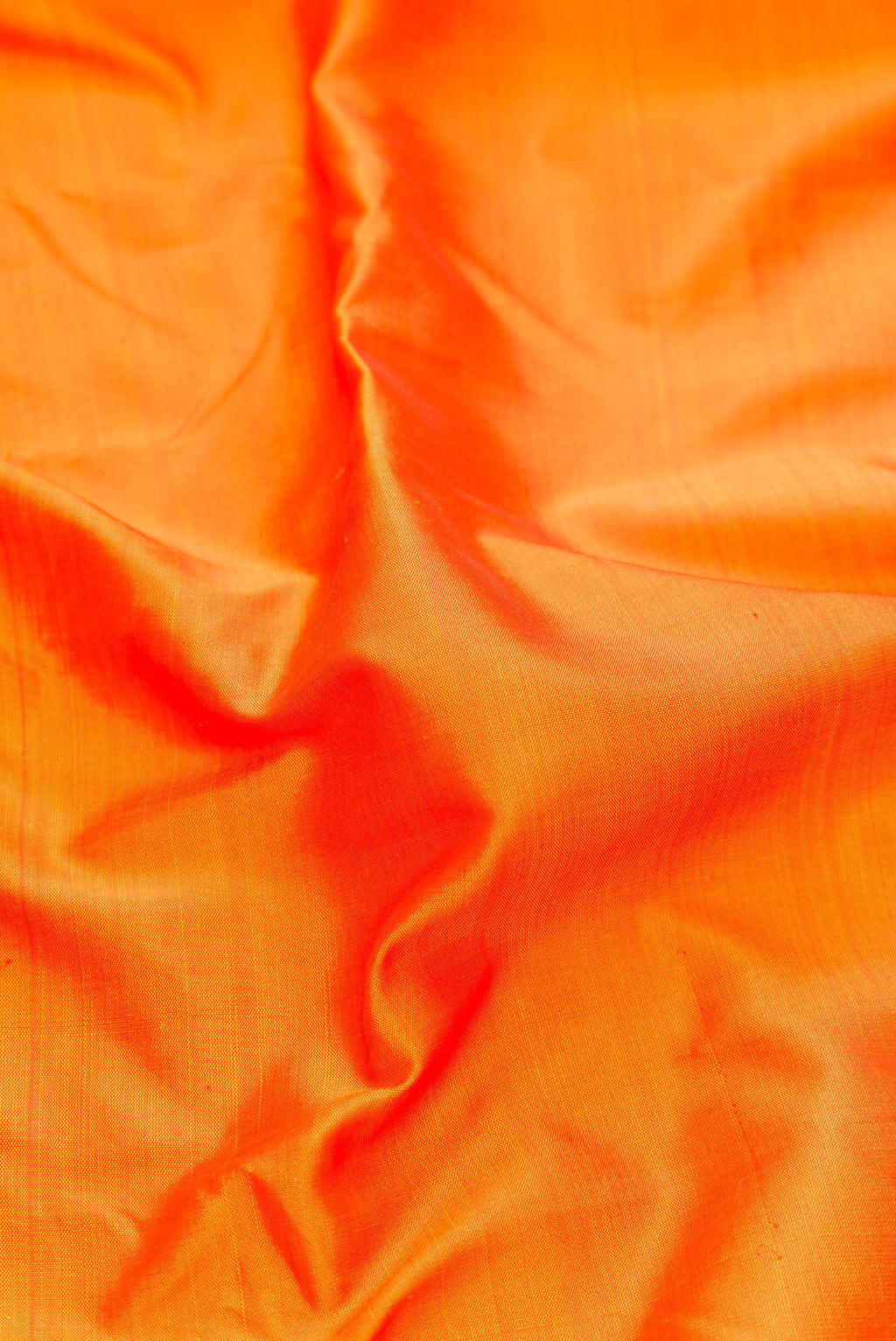 Close up of Pure Silk Pure Zari Orange Kanjivaram Saree with Plain Body and One Side Border.  displaying folds