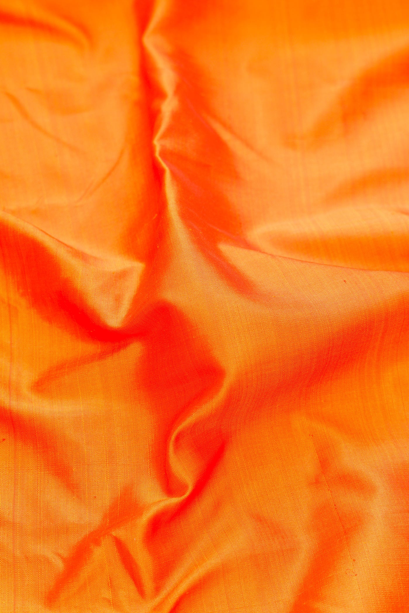 Close up of Pure Silk Pure Zari Orange Kanjivaram Saree with Plain Body and One Side Border.  displaying folds