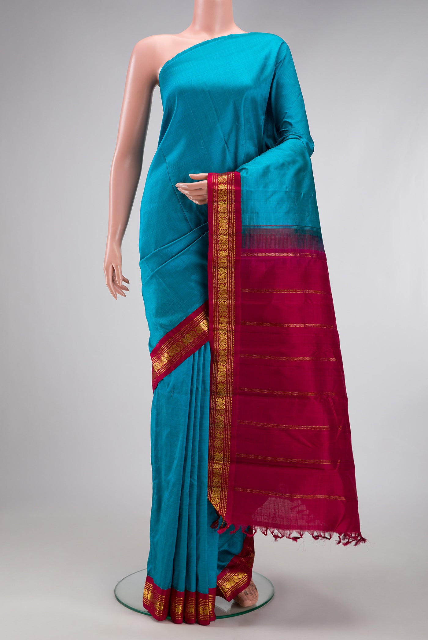 Pure Silk Pure Zari Peacock Blue Kanjivaram Saree with Plain Body and One Side Border.  displayed on a mannequin
