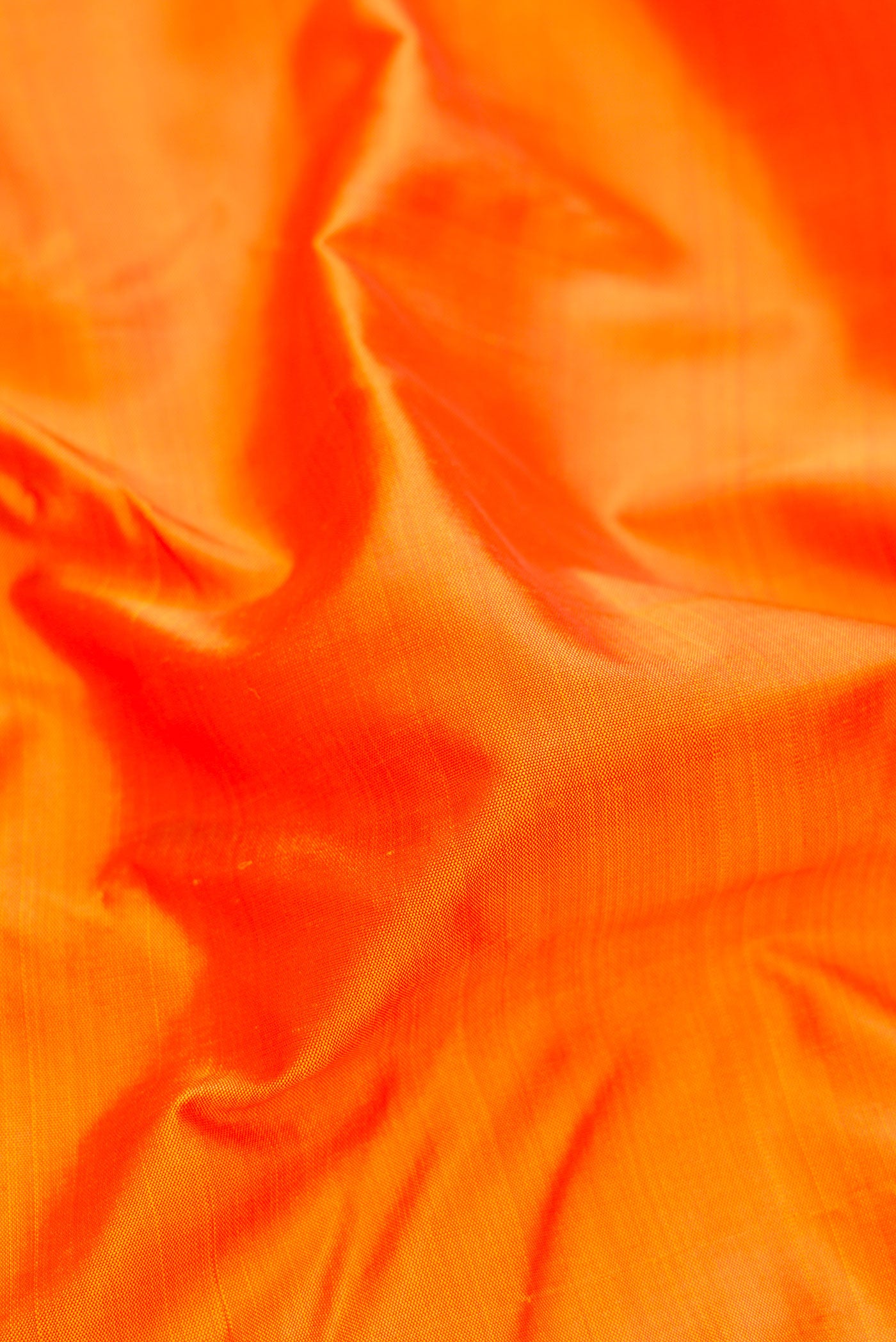 Close up of Pure Silk Pure Zari Orange Kanjivaram Saree with Plain Body and One Side Border.  displaying folds