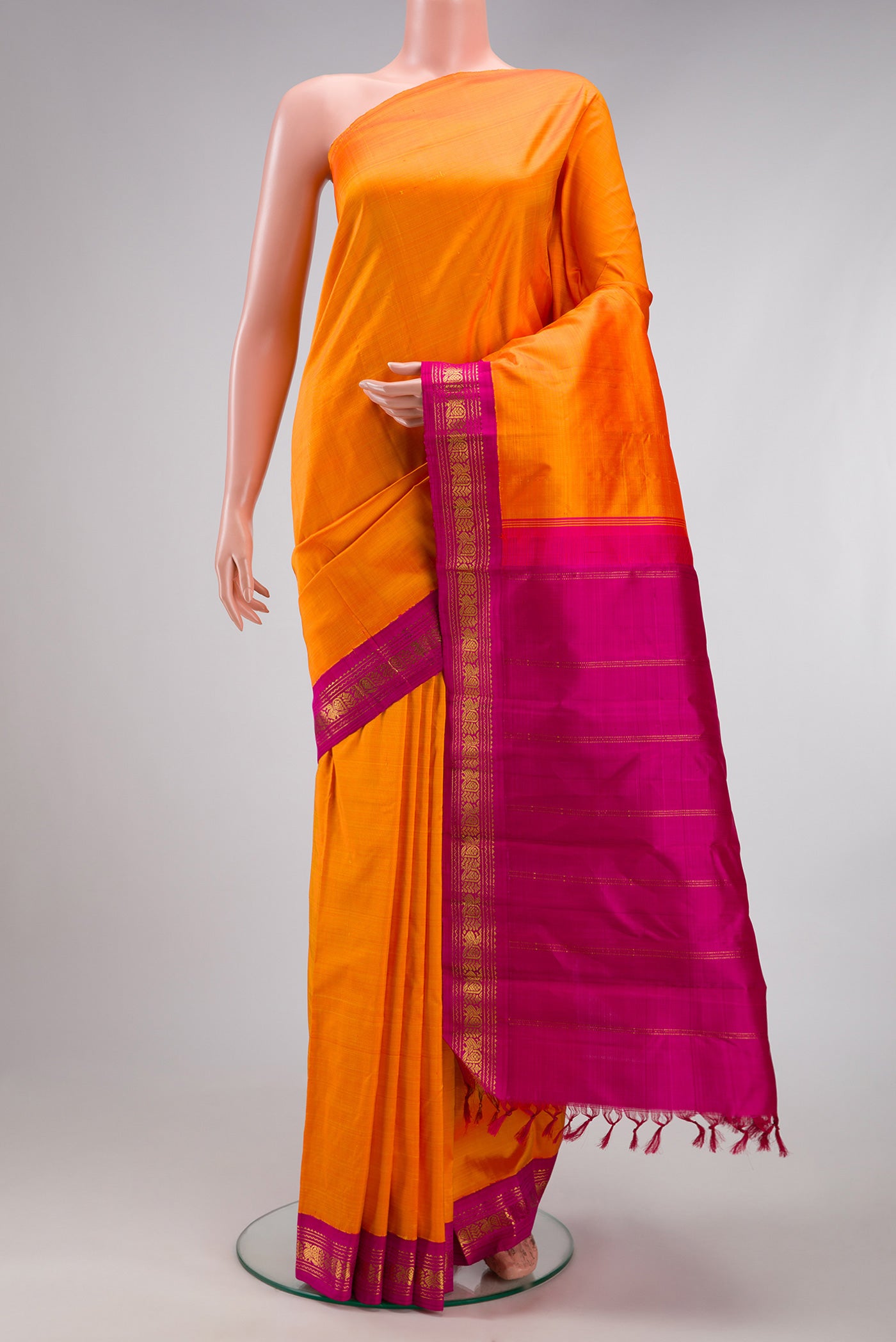 Pure Silk Pure Zari Orange Kanjivaram Saree with Plain Body and One Side Border.  displayed on a mannequin