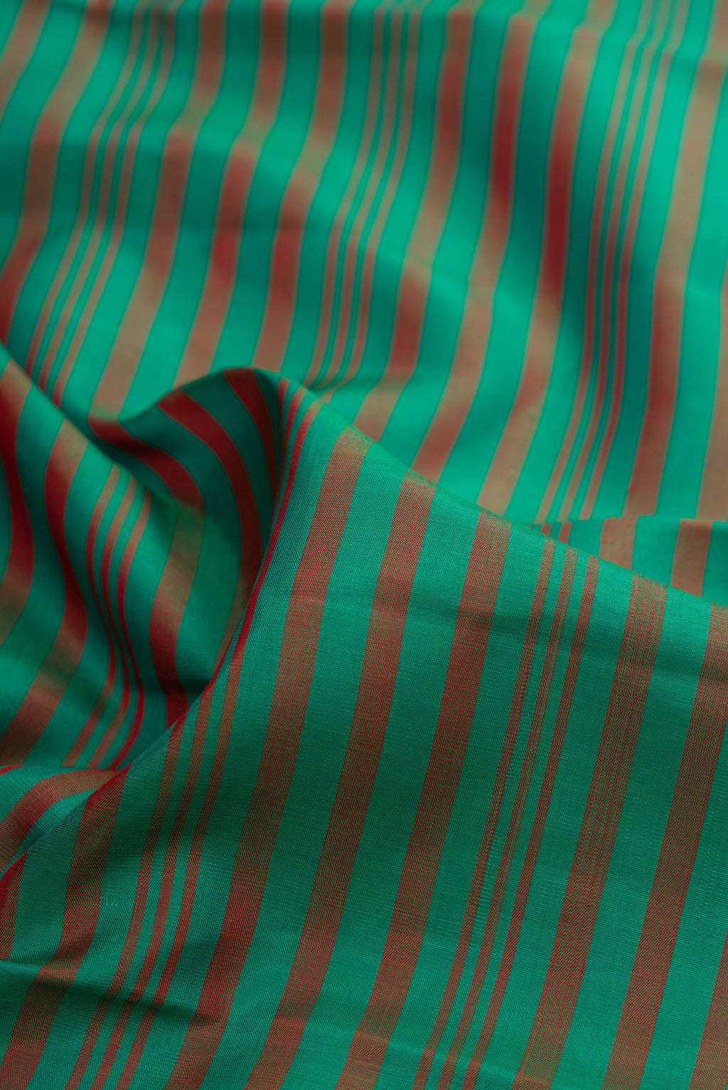 Close up of Bottle Green Dual Tone Kanjivaram Silk Saree with Stripes on the body and Temple Border.  displaying folds