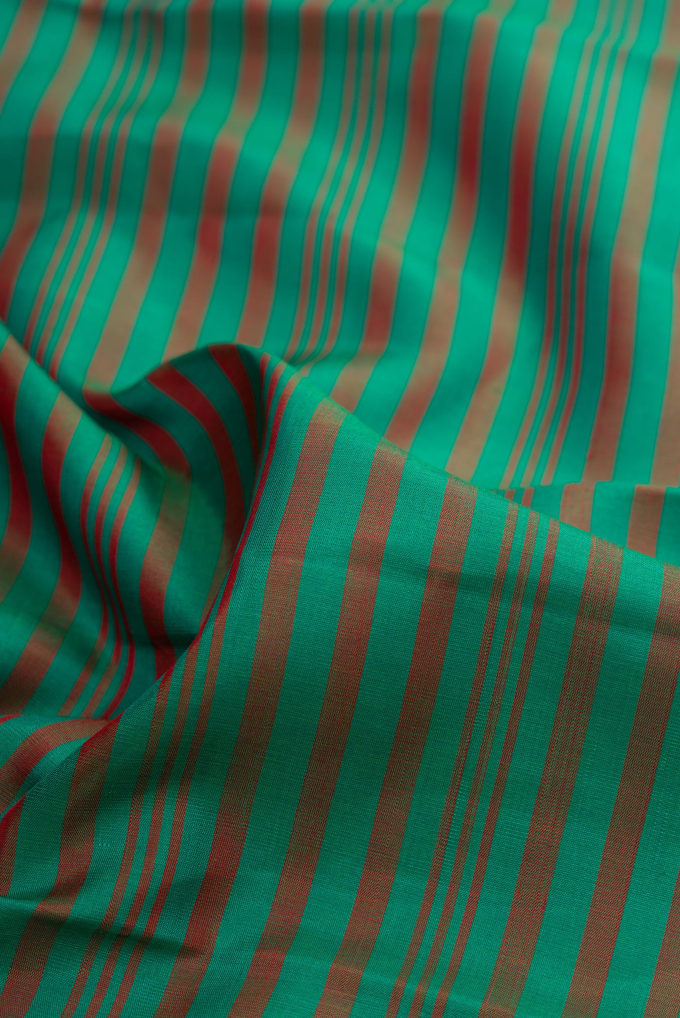 Close up of Bottle Green Dual Tone Kanjivaram Silk Saree with Stripes on the body and Temple Border.  displaying folds