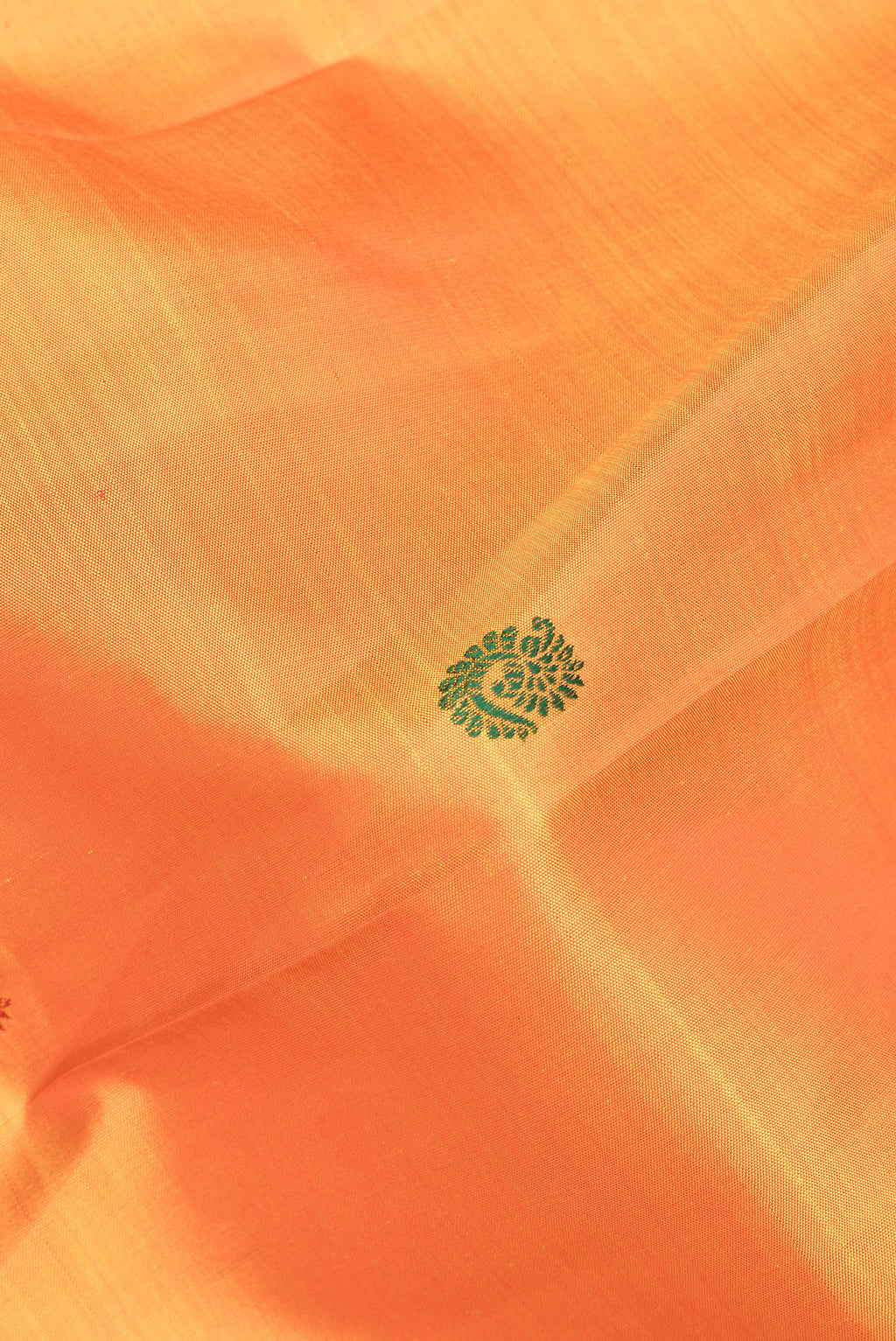 Close up of Pure Silk Orange Kanjivaram Saree with Thread Butta on the body and Zari Border.  displaying folds