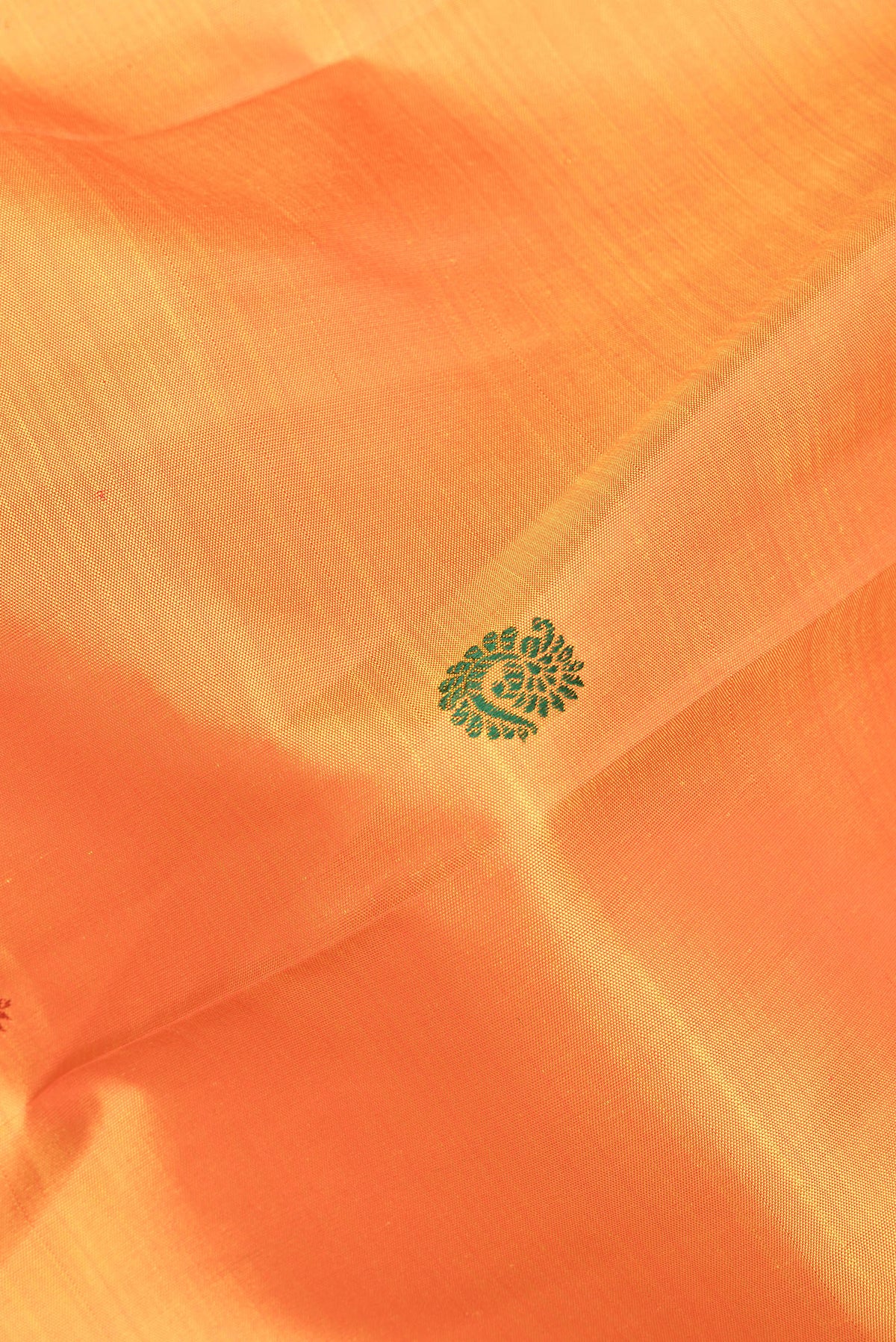 Close up of Pure Silk Orange Kanjivaram Saree with Thread Butta on the body and Zari Border.  displaying folds
