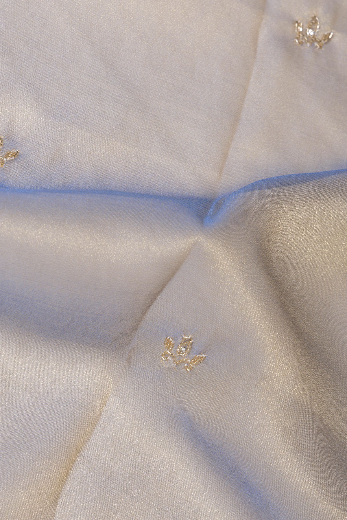Close up of Gold with Blue Color Organza Saree with Embroidery on the body and Sequin Border.  displaying folds