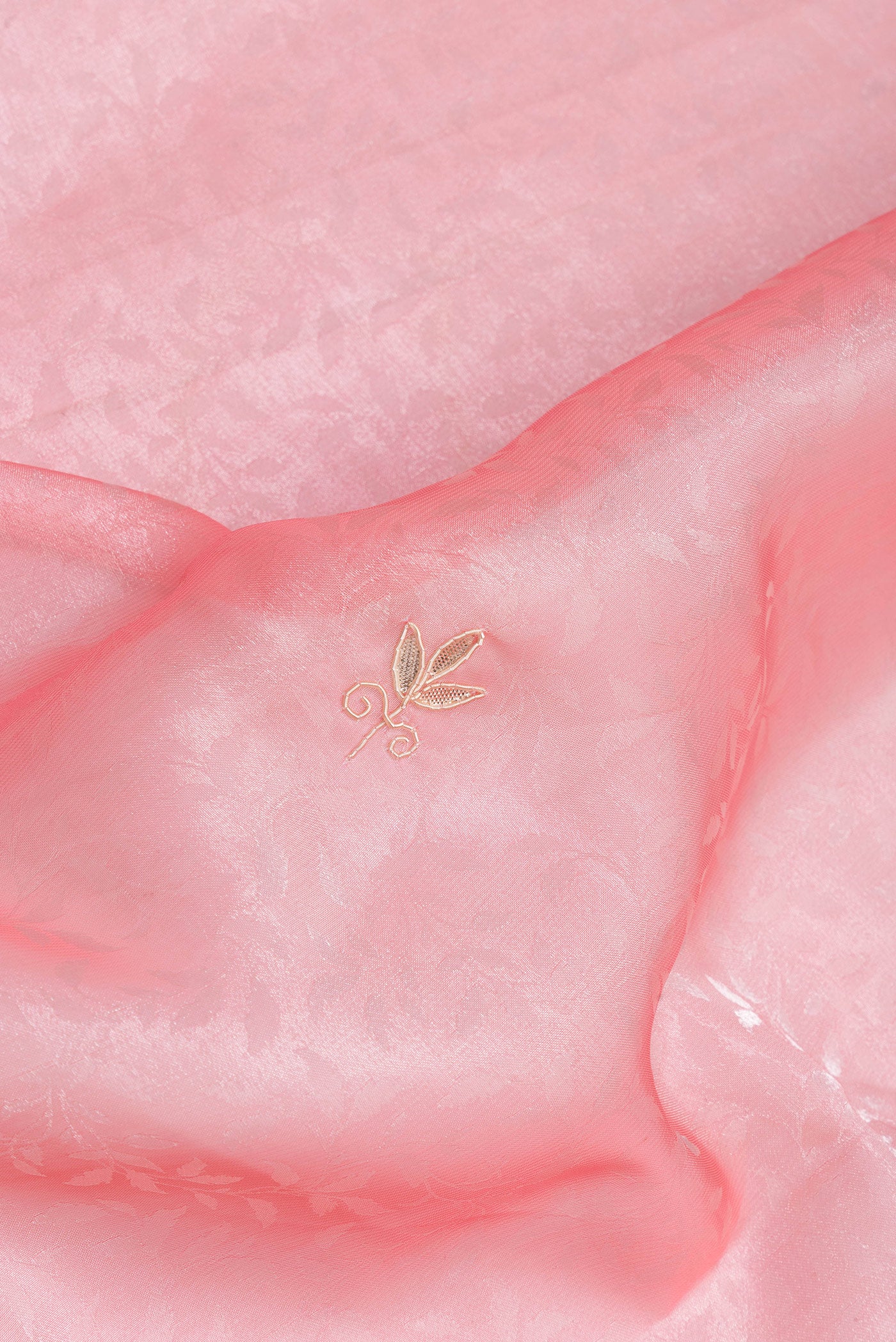 Close up of Pink Organza Silk Saree with Embroidery on the body and Embroidery Border.  displaying folds