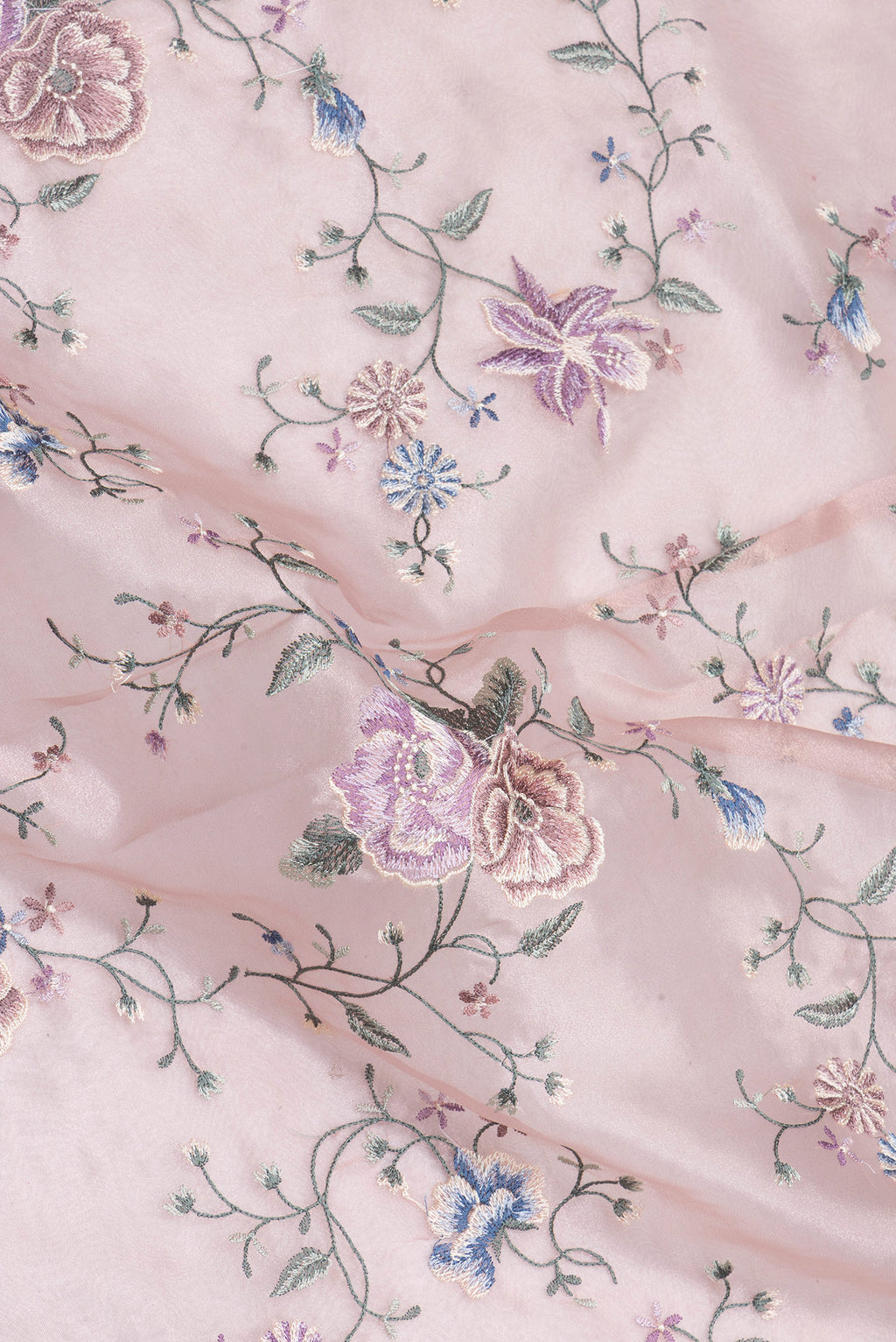 Close up of Rose Gold Organza Silk Saree with Embroidery on the body and Embroidery Border.  displaying folds