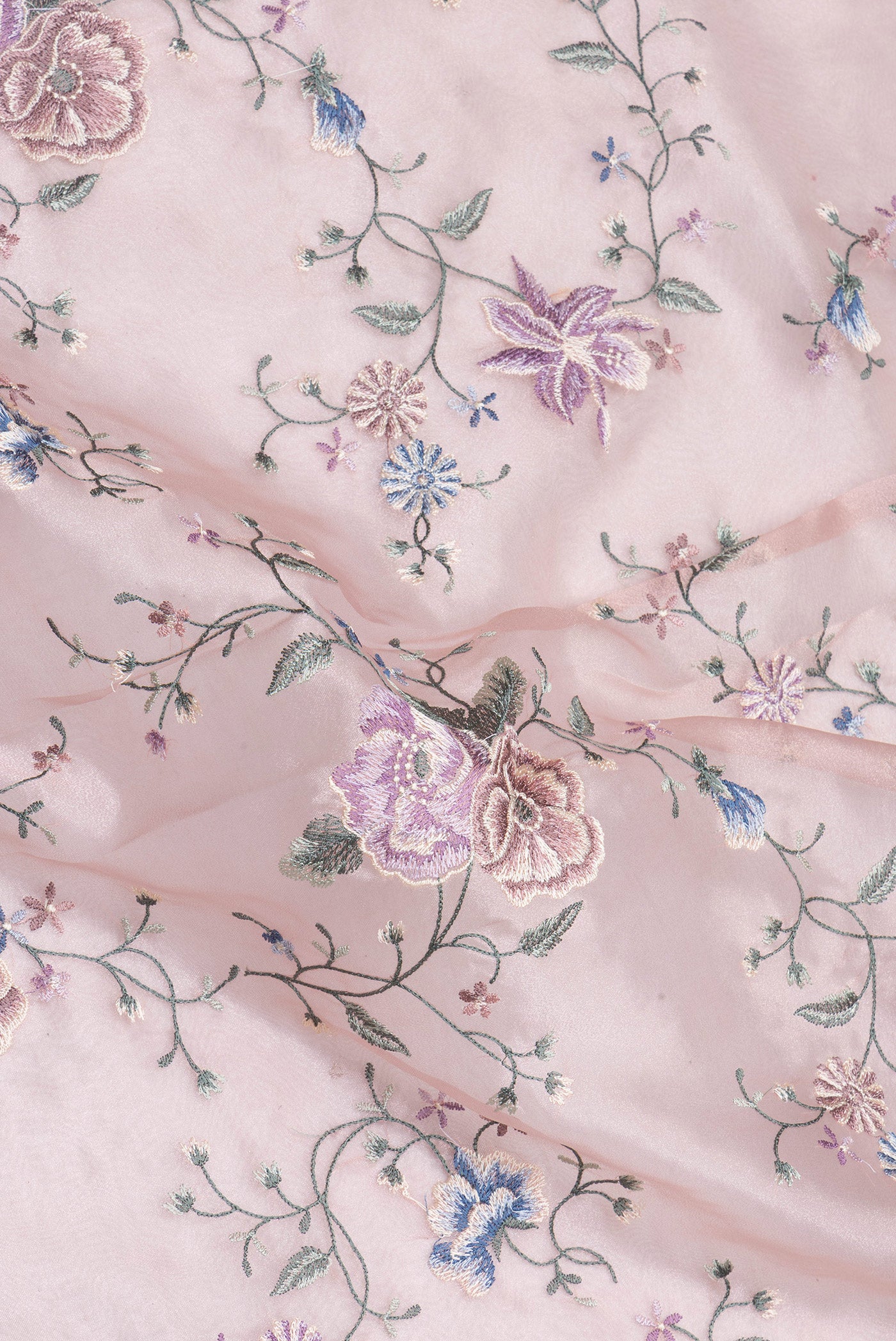 Close up of Rose Gold Organza Silk Saree with Embroidery on the body and Embroidery Border.  displaying folds