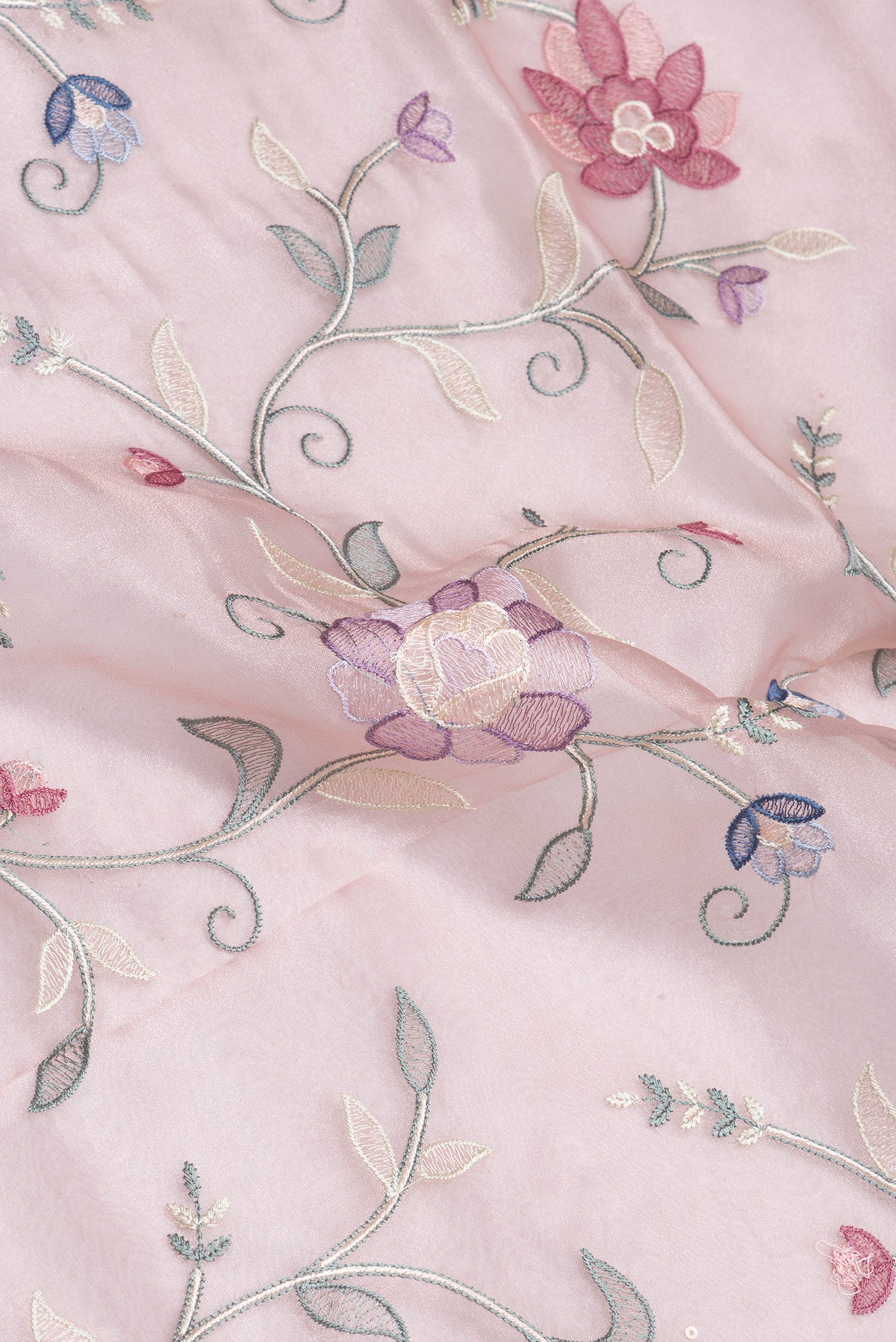 Close up of Rose Gold Organza Silk Saree with Embroidery on the body and Embroidery Border.  displaying folds