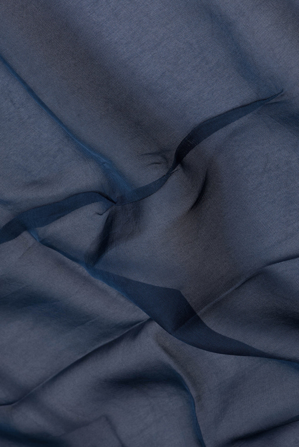 Close up of Navy Blue Organza Silk Saree with Embroidery on the body and Thread Embroidery Border.  displaying folds