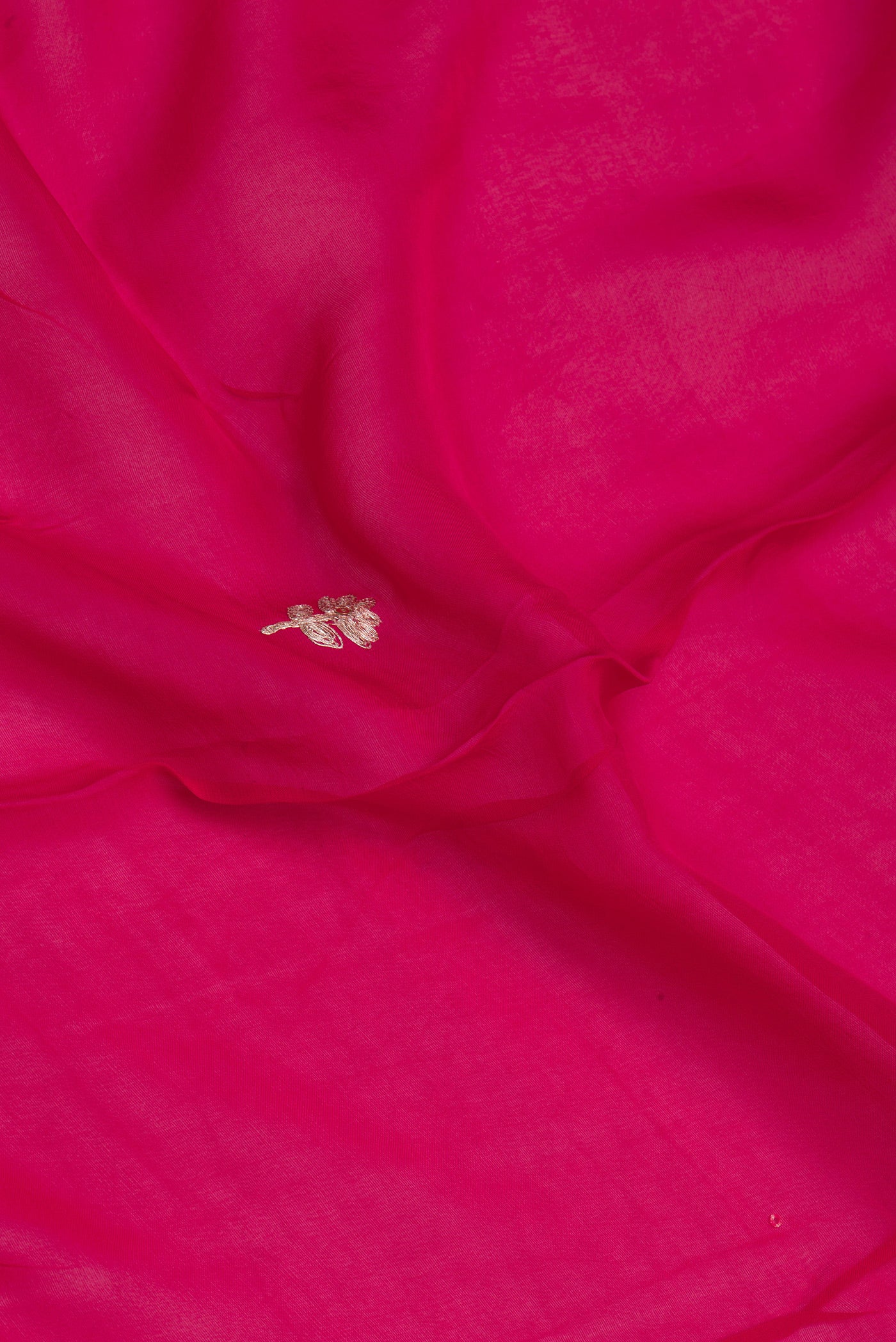 Close up of Dark Pink Organza Silk Saree with Embroidery on the body and Sequin Border.  displaying folds