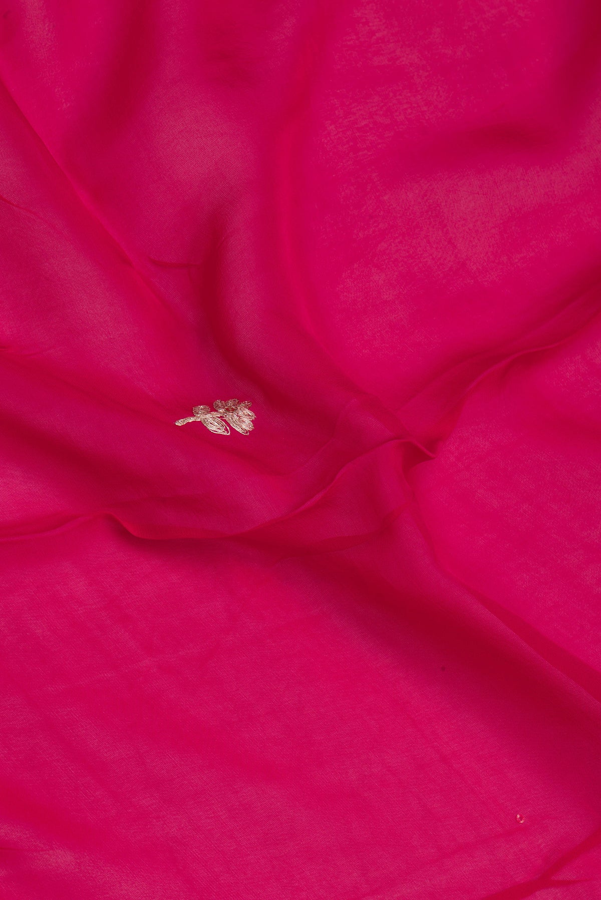 Close up of Dark Pink Organza Silk Saree with Embroidery on the body and Sequin Border.  displaying folds