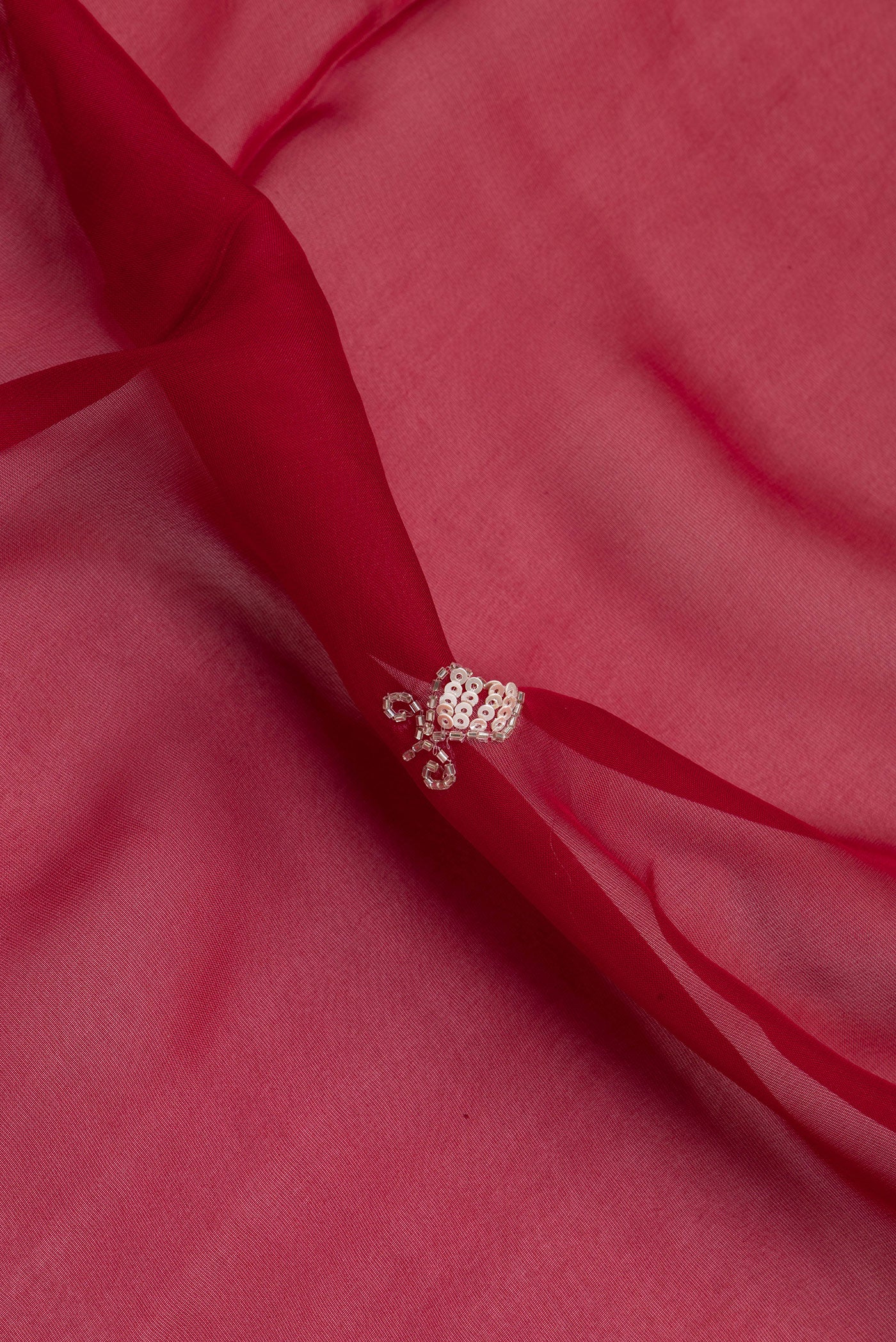 Close up of Maroon Organza Silk Saree with Embroidery on the body and Sequin Border.  displaying folds