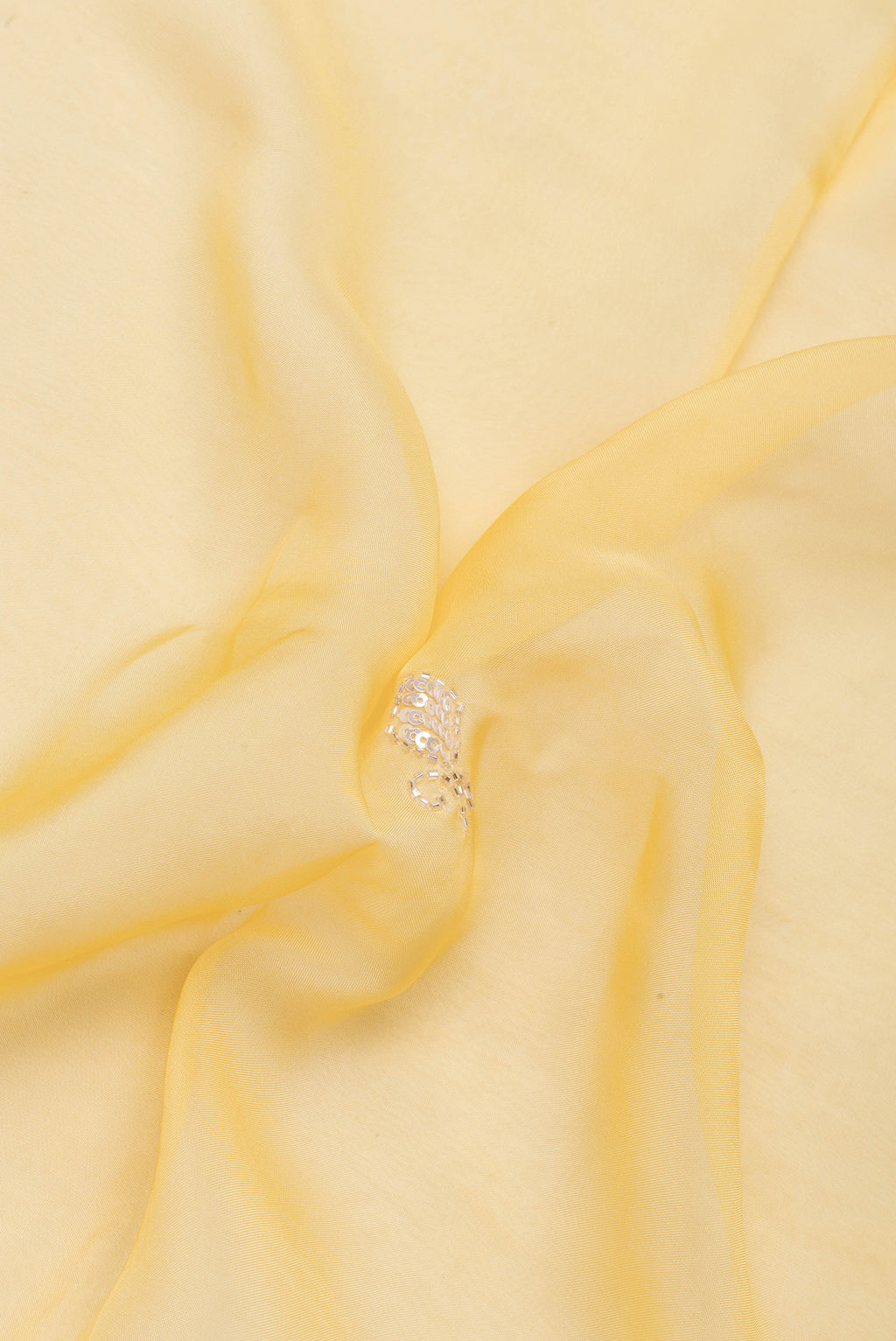 Close up of Sandal Organza Silk Saree with Embroidery on the body and Sequin Border.  displaying folds